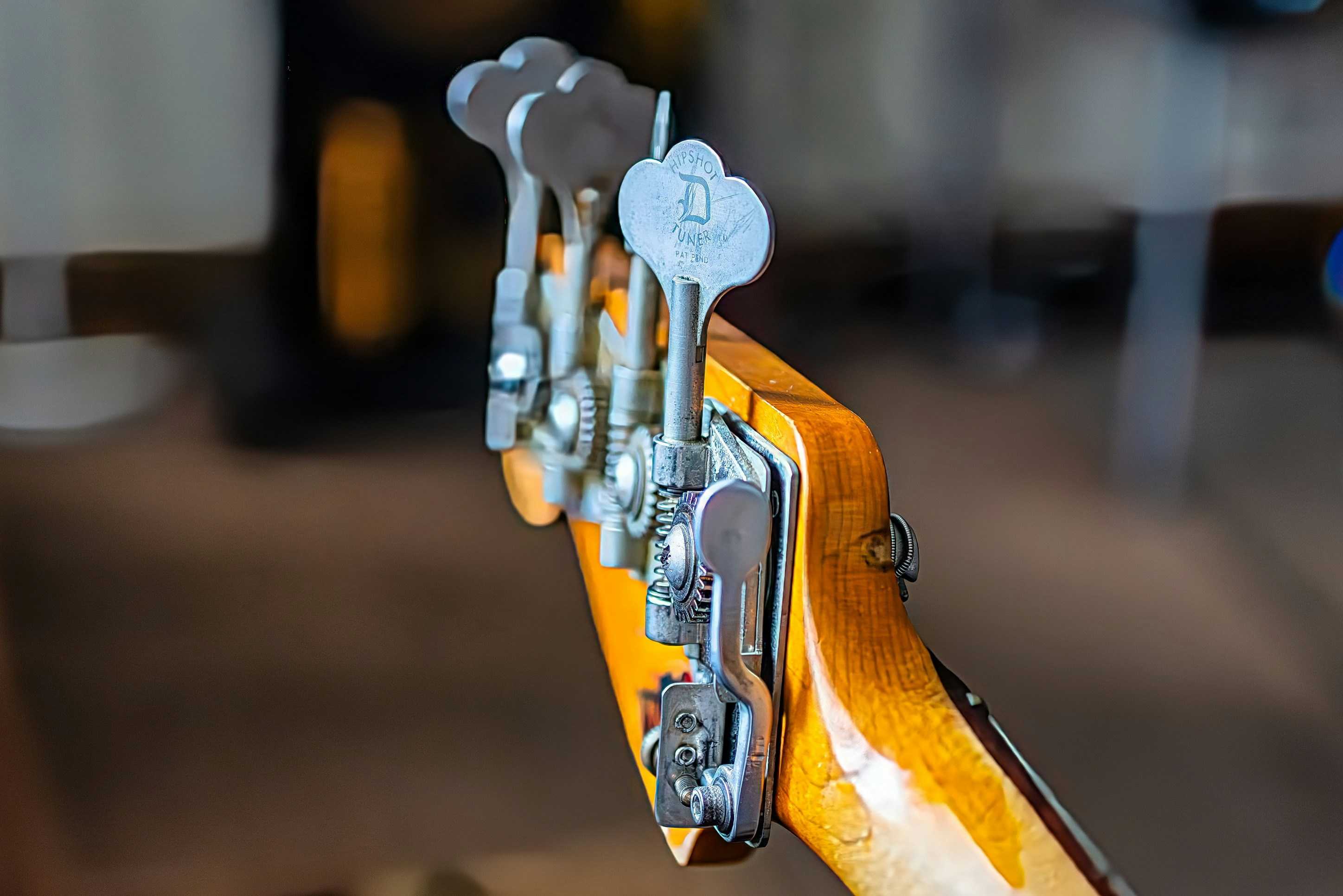 A bass guitar's headstock is up close.