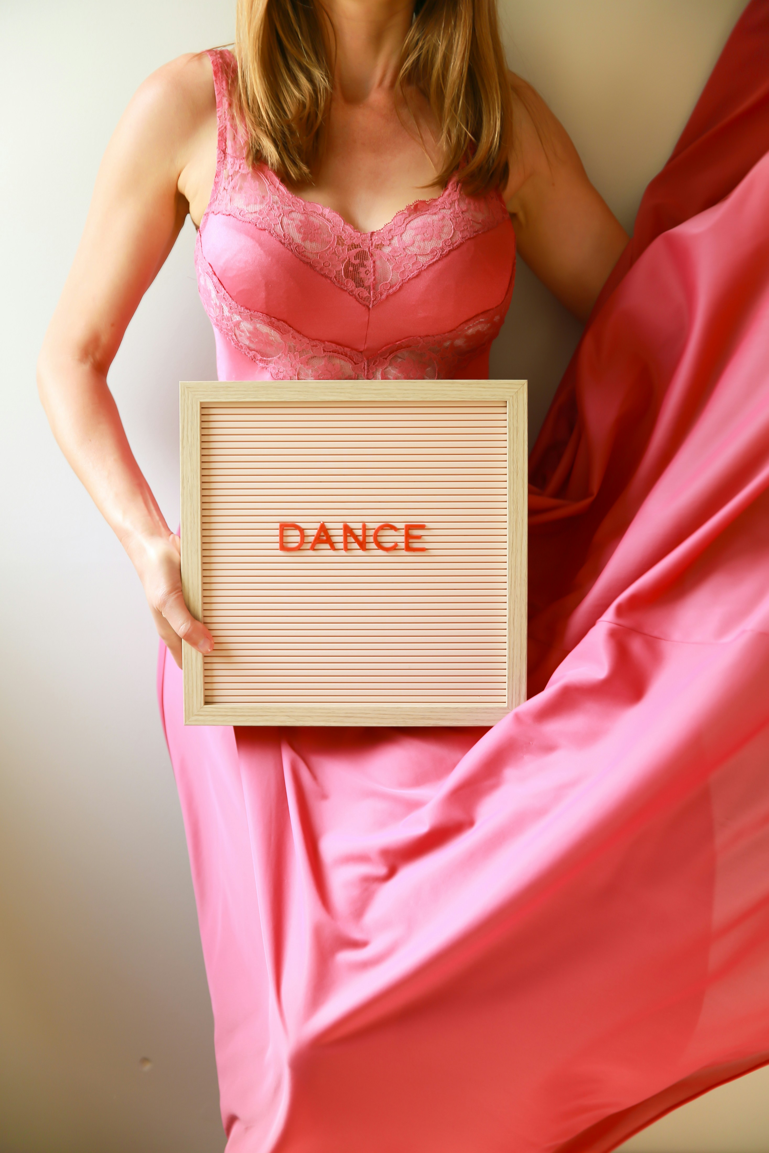 A woman holds a sign that says "dance."