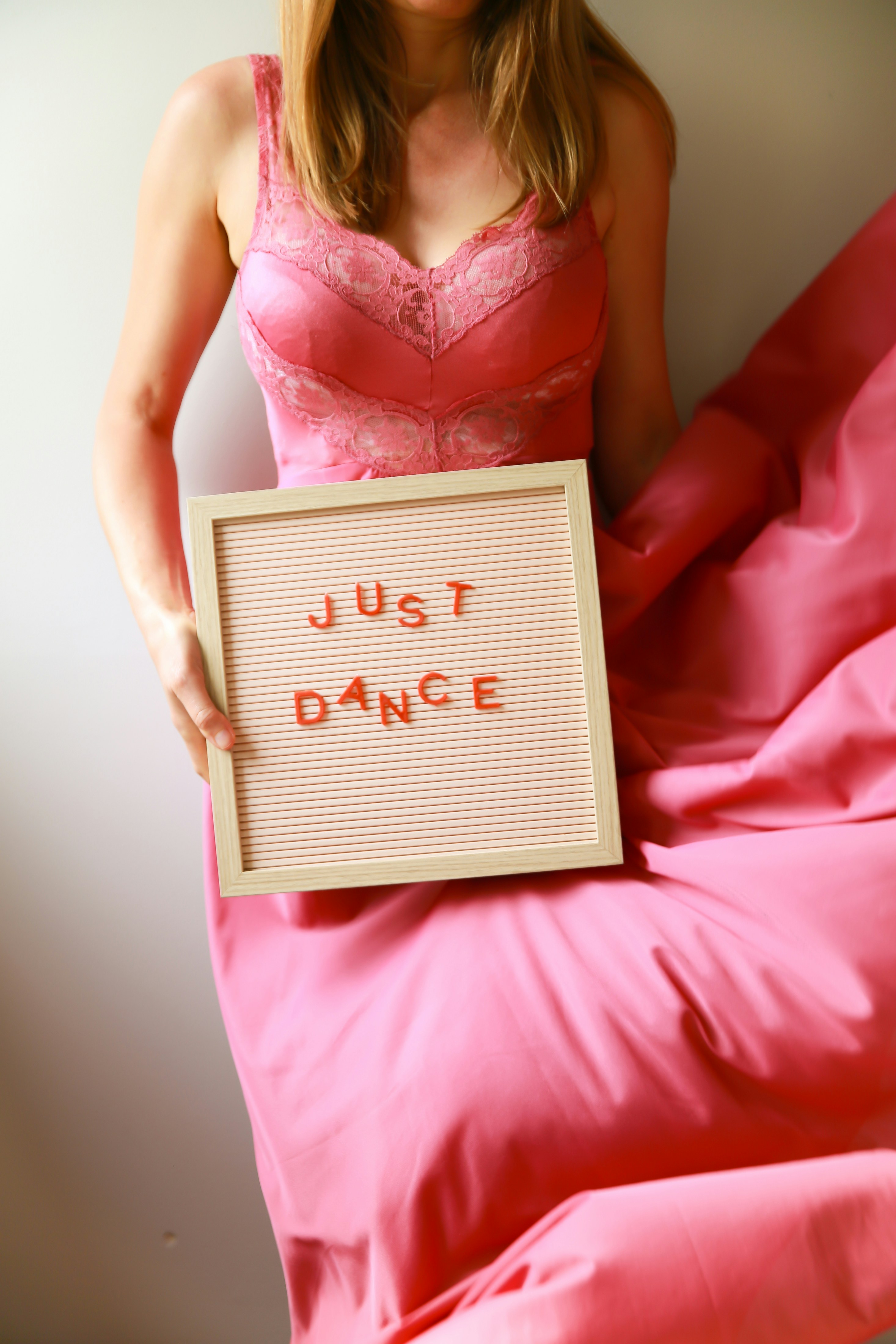 Woman holds a sign that says "just dance."