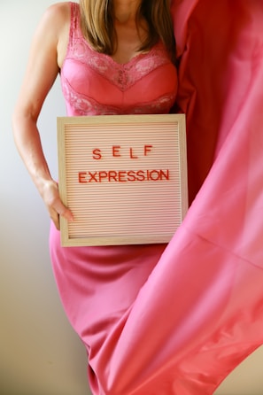 Woman holding a sign that reads "self expression".