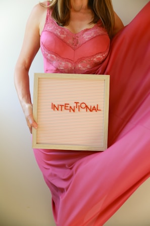 Woman holds a sign reading "intentional".