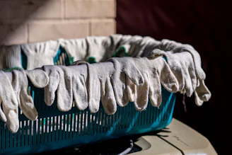 Gloves are hanging over the edge of a basket.