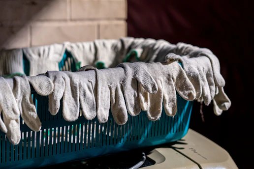 Gloves are hanging over the edge of a basket.