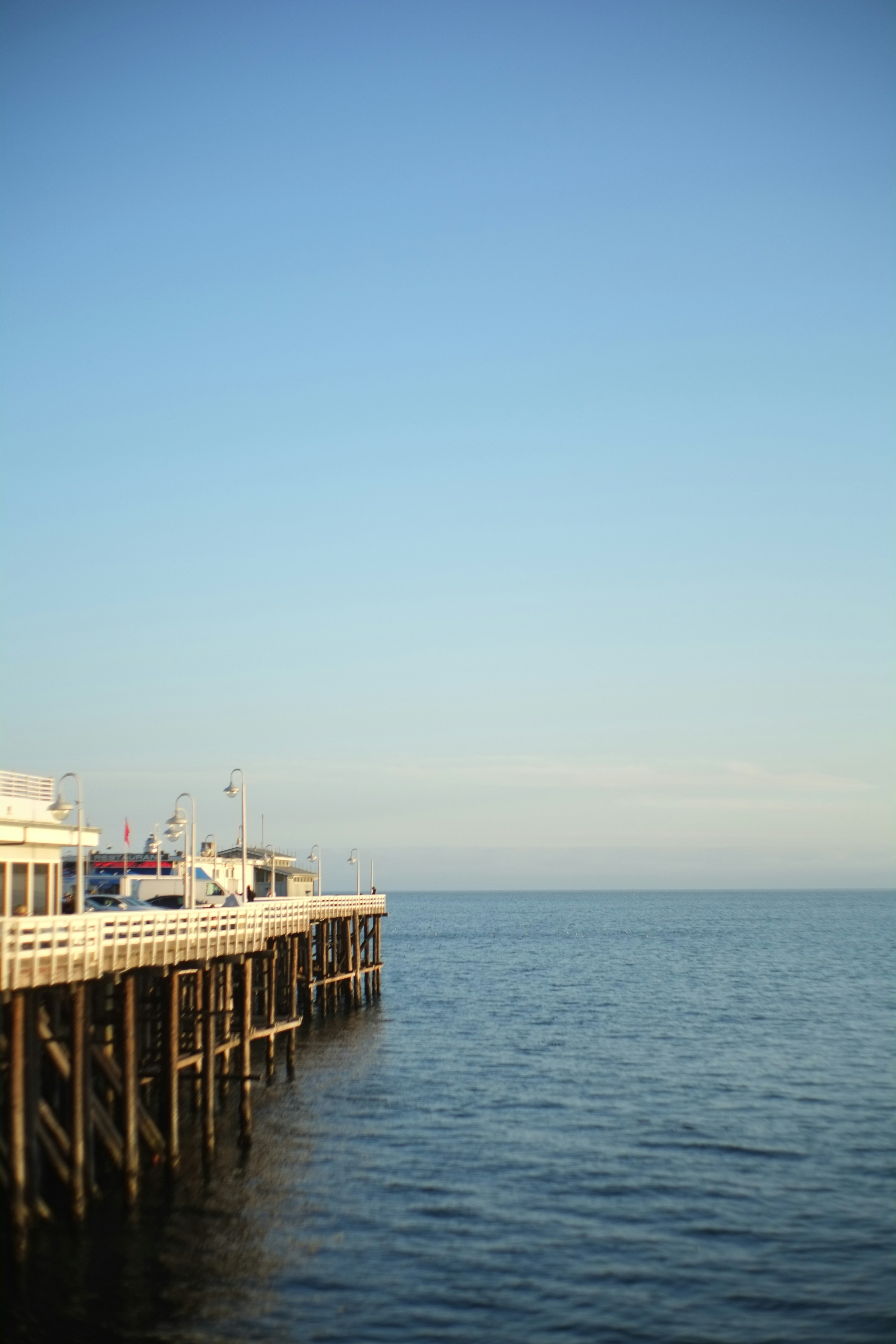 A pier extends into calm waters.