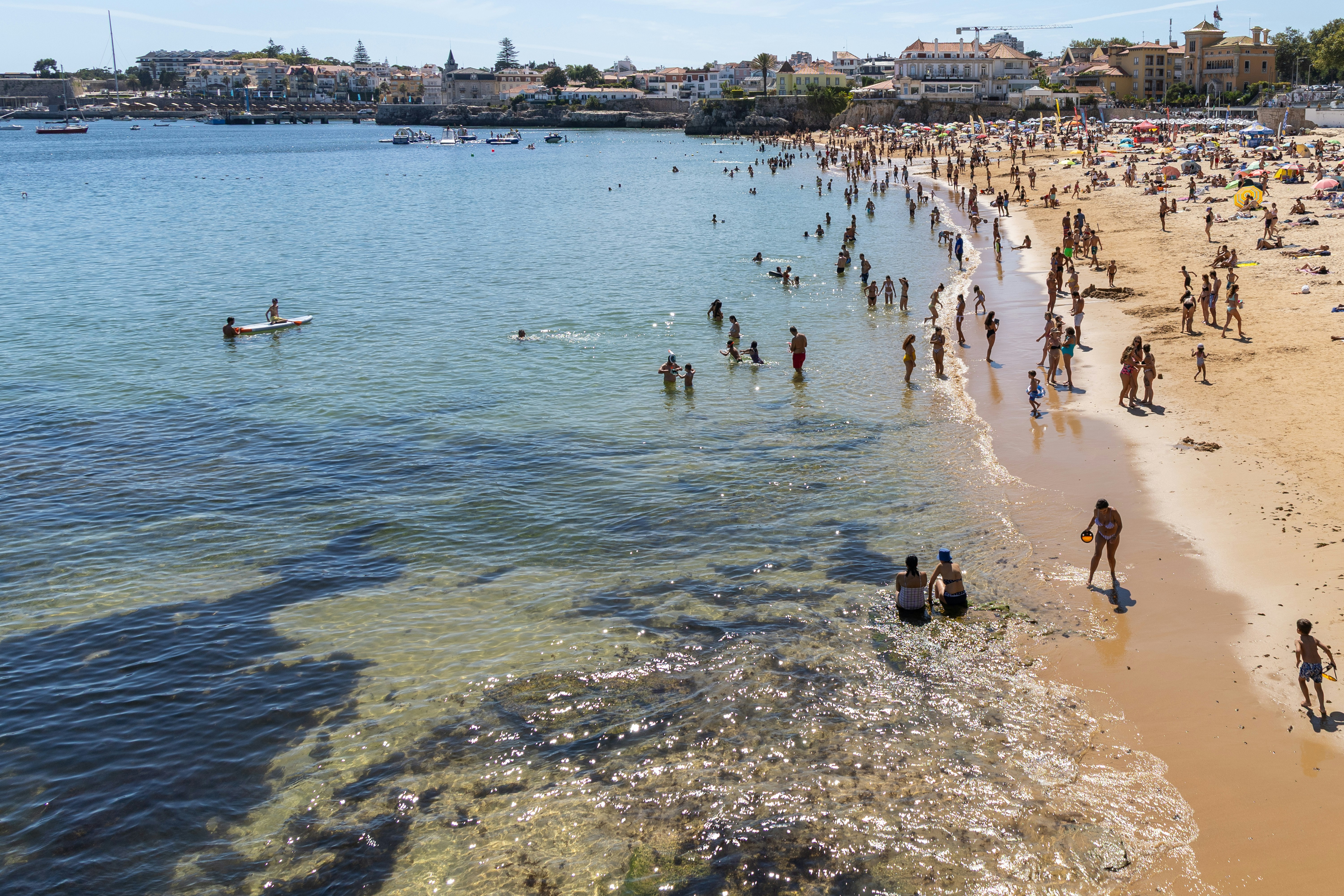 Beachgoers enjoy a sunny day at the coast.