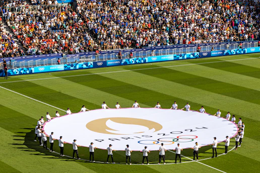 People hold the olympic flag on a field