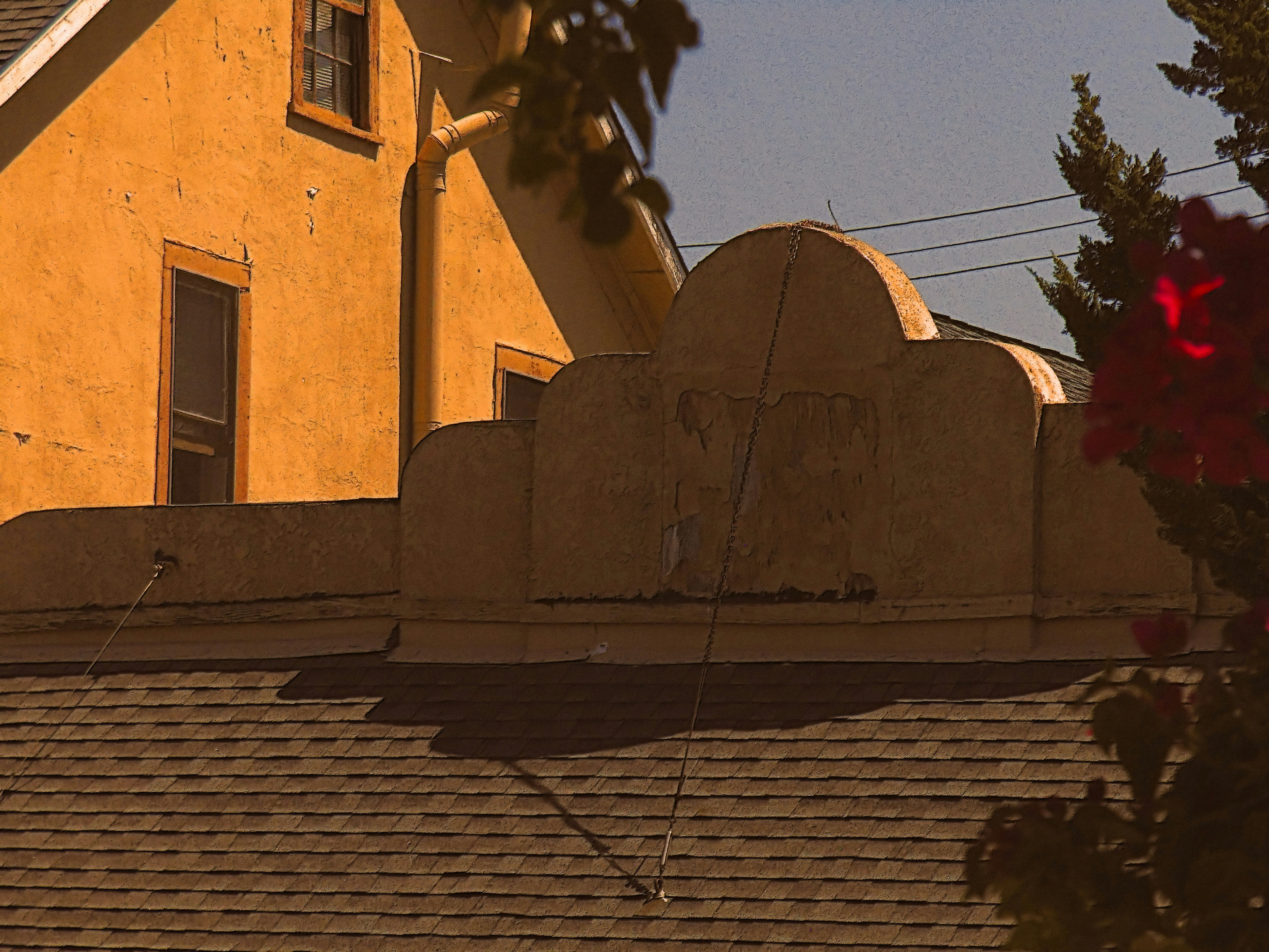 A sunny, yellow building appears from behind foliage.