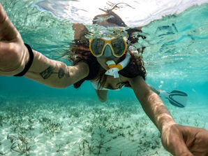 Woman snorkeling in the clear, blue ocean.