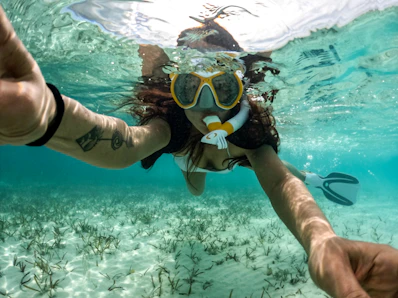 Woman snorkeling in the clear, blue ocean.
