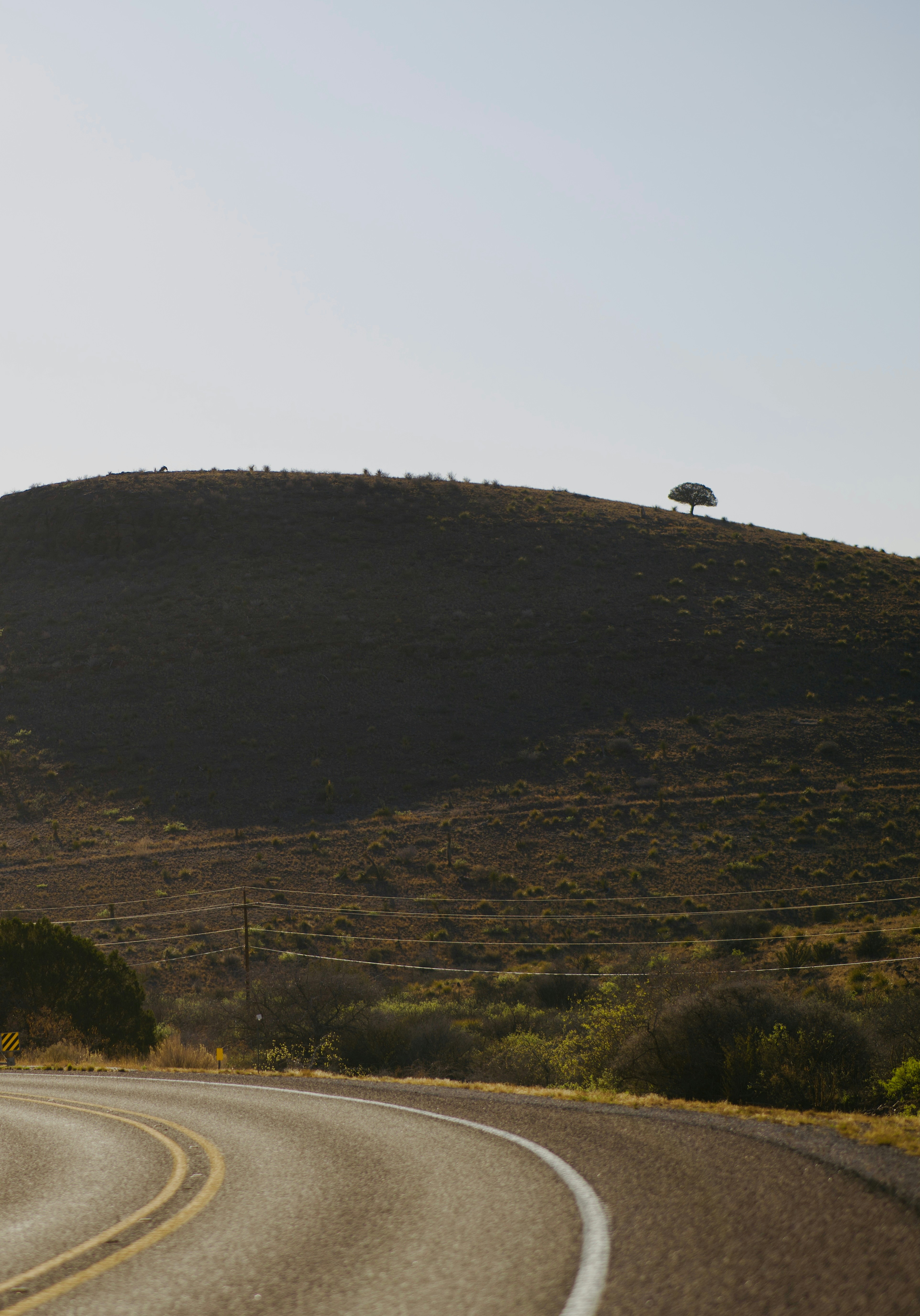A winding road leads towards a distant hill.