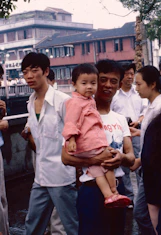 People pose outdoors with a child in the city.