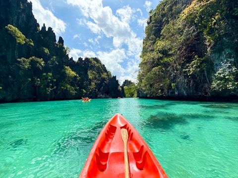 Kayaking through turquoise water surrounded by mountains.