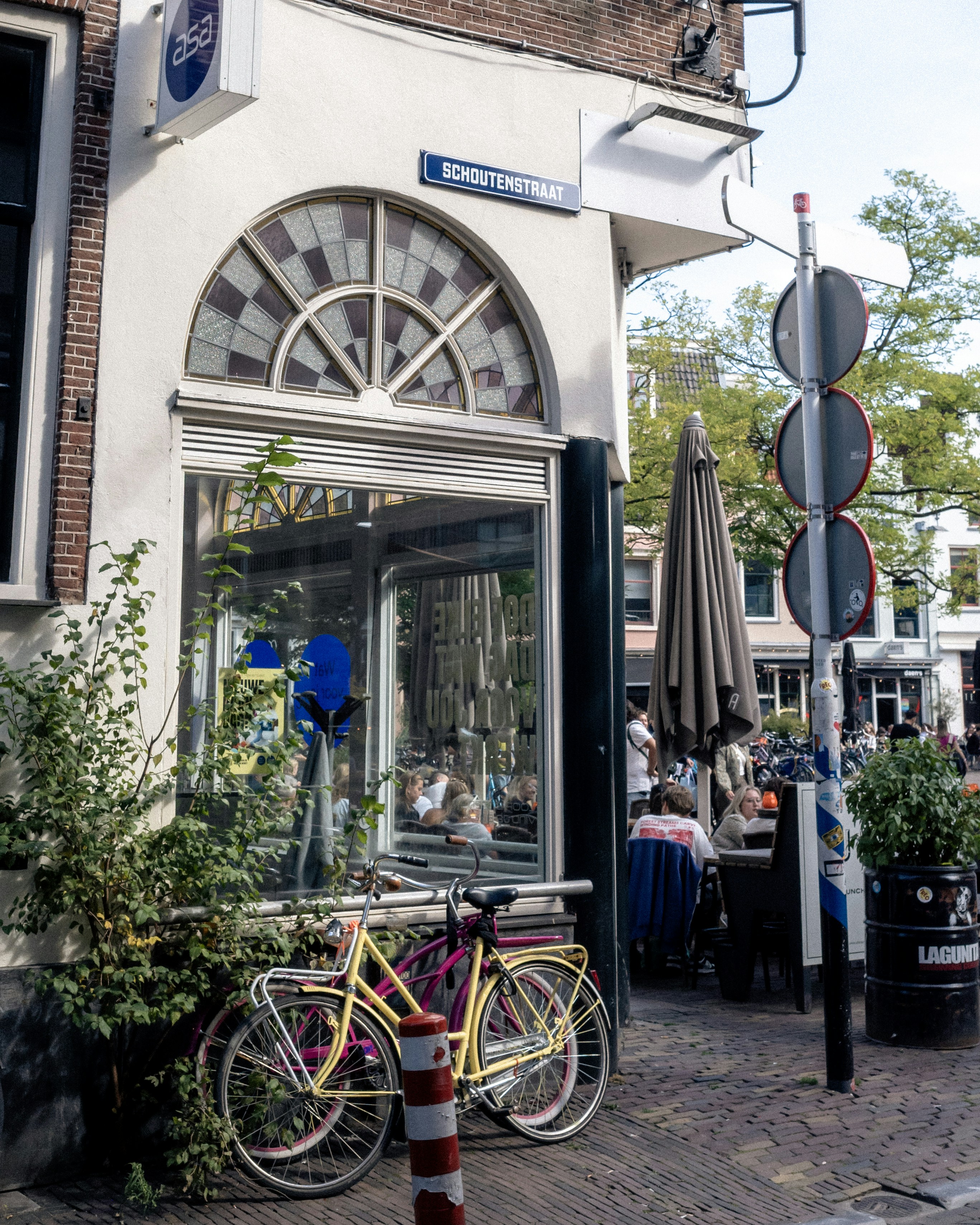 Bicycles sit outside a cafe with outdoor seating.