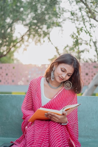 A woman reads a book in the park.