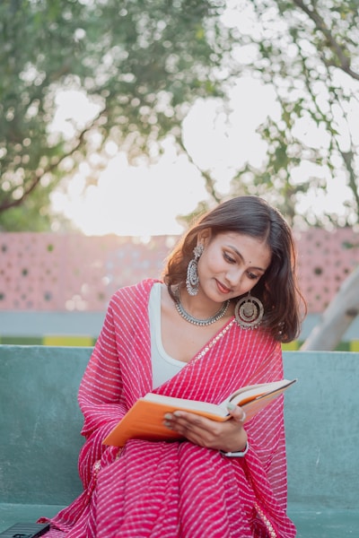 A woman reads a book in the park.