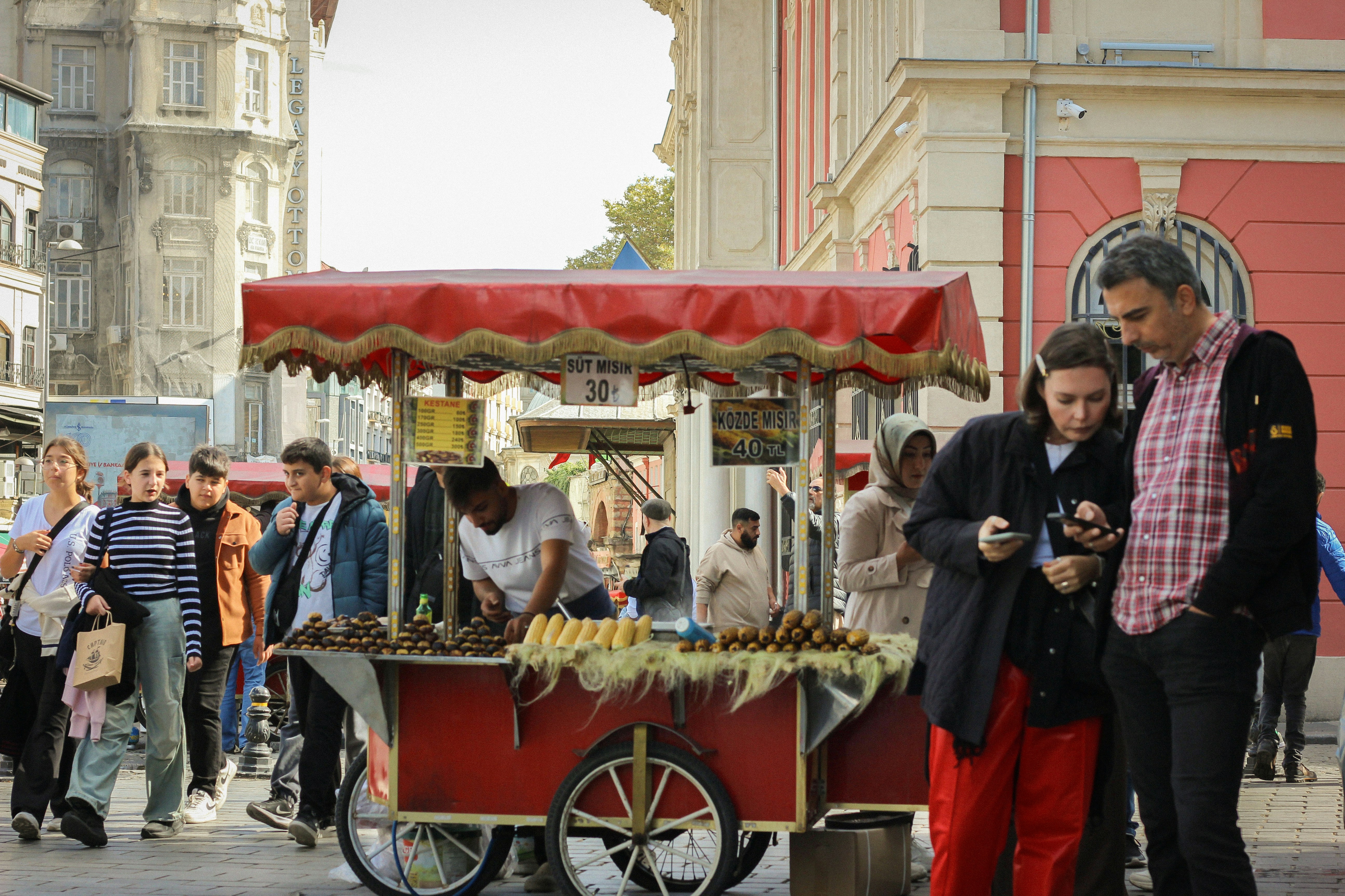 Un vendeur ambulant vend de la nourriture dans une ville animée.