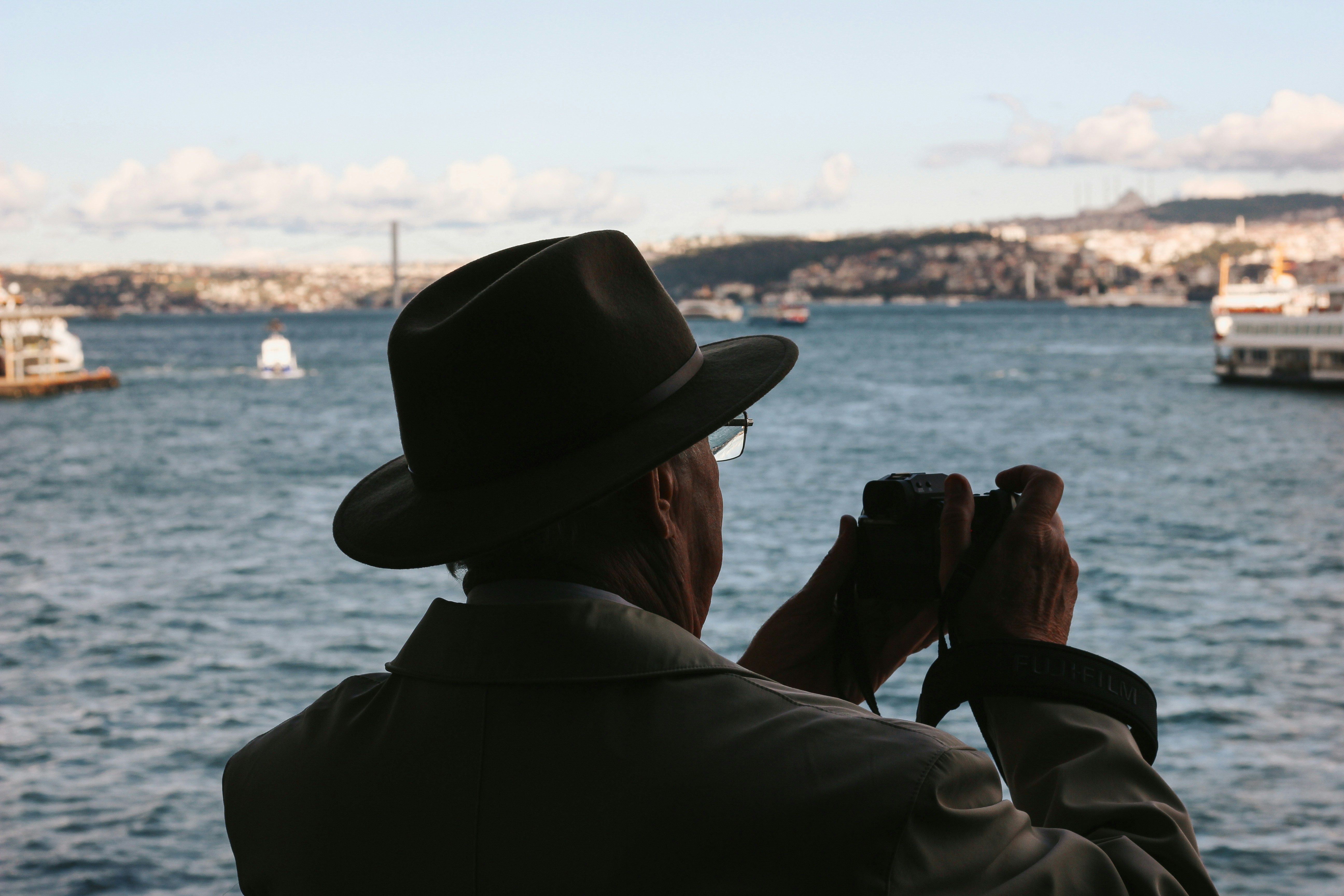 L’homme avec un chapeau prend une photo de la mer.