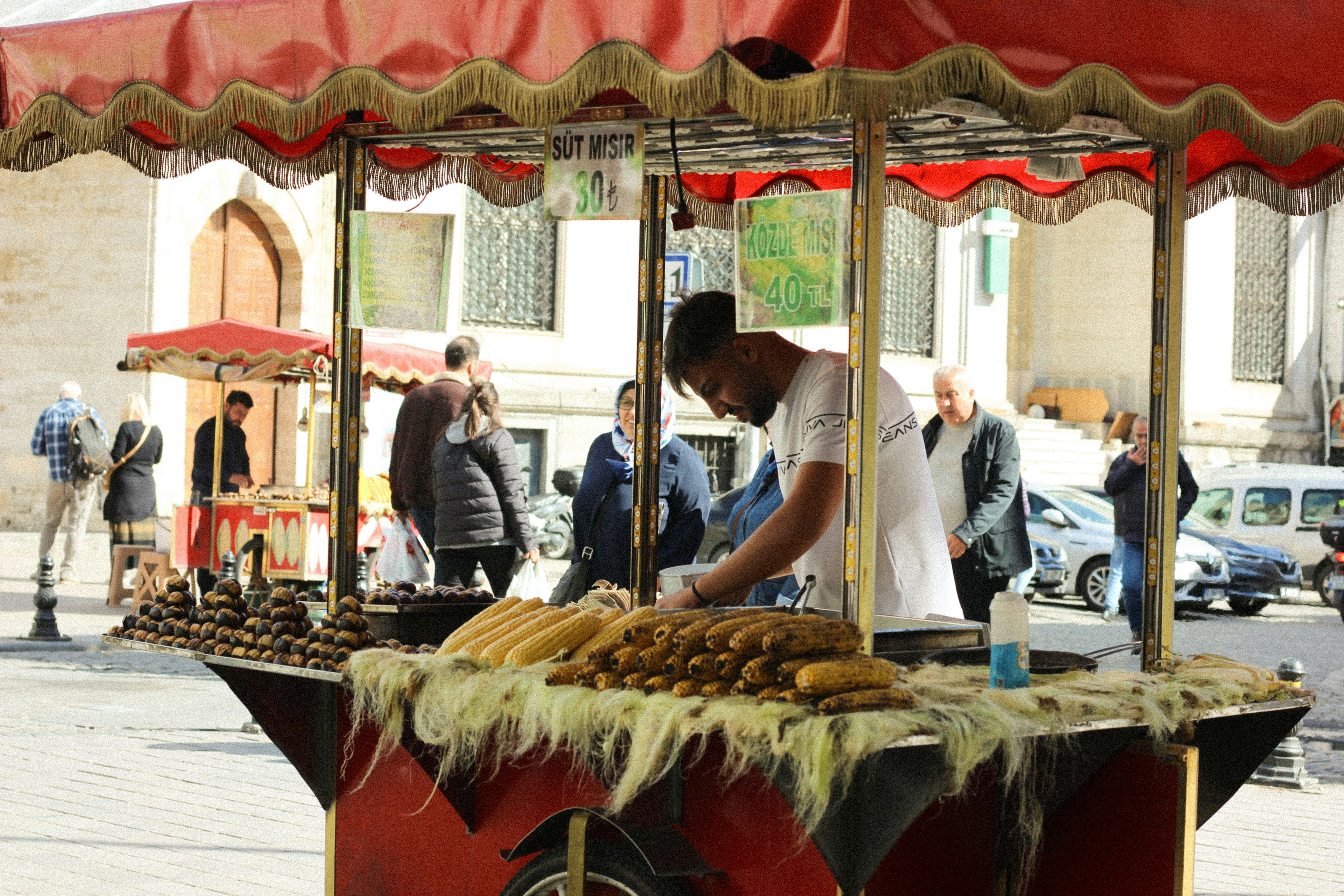 A street vendor is preparing corn for customers.