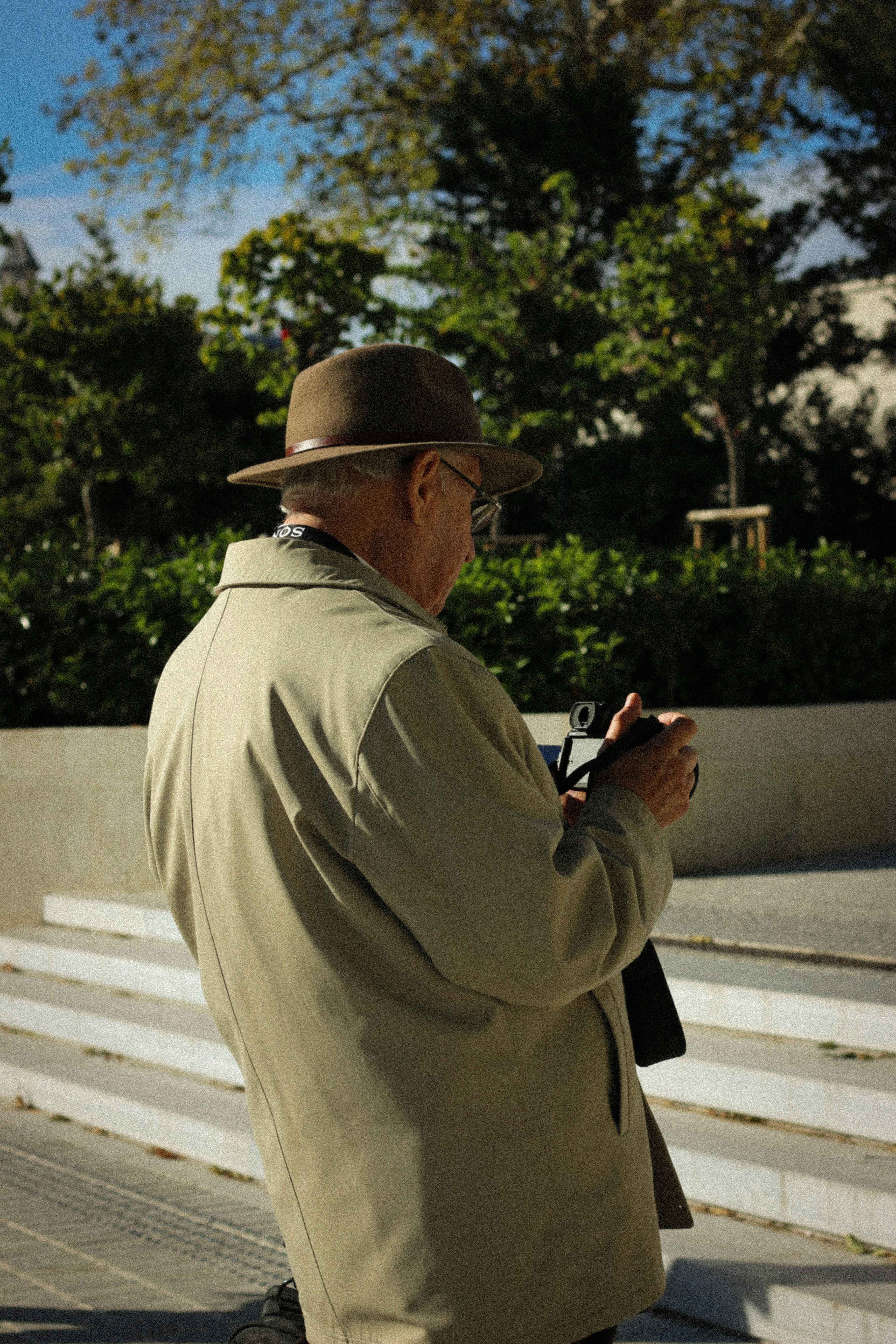 Un homme âgé prend des photos à l’extérieur.