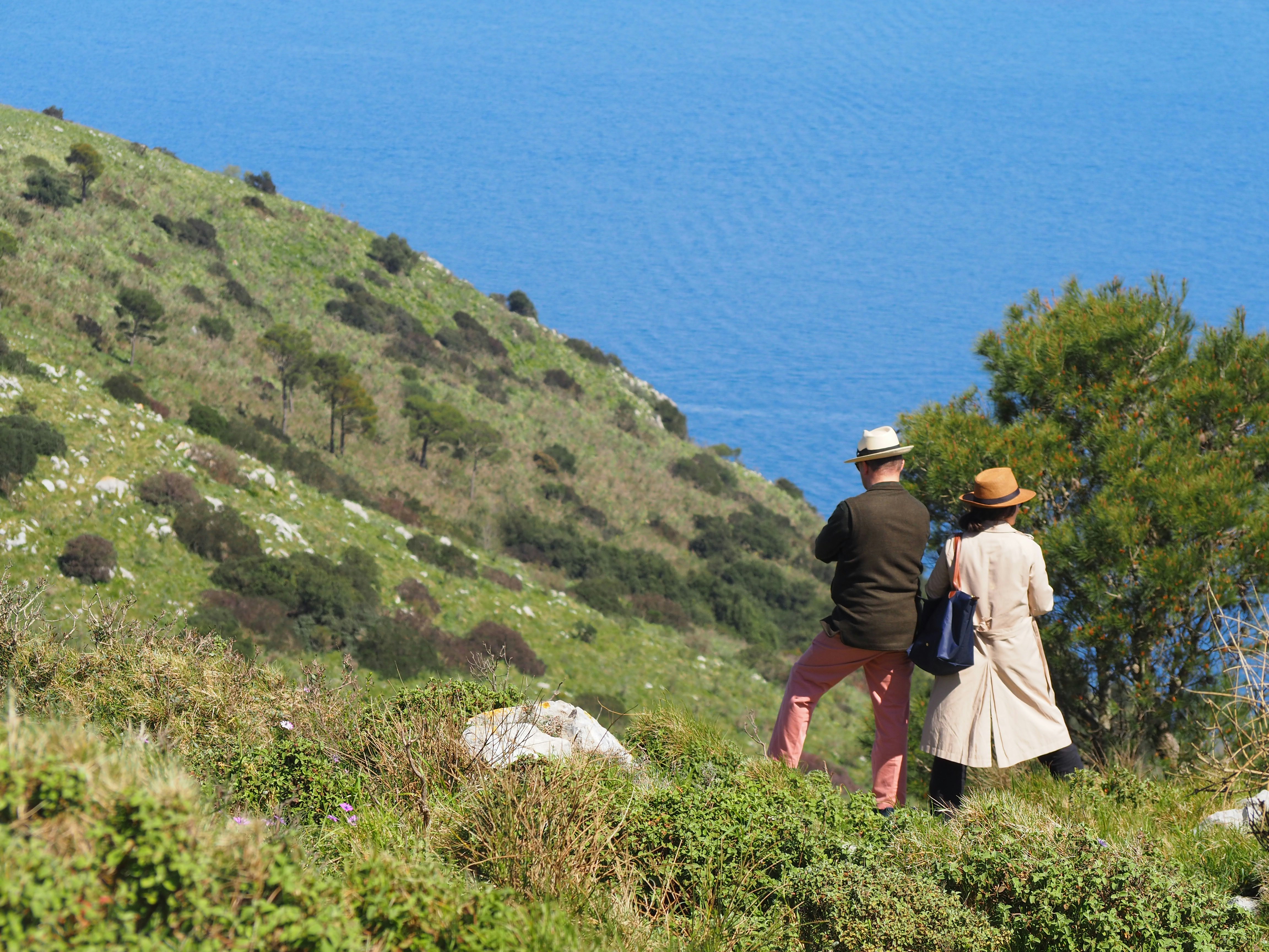 Two people admire the view of the blue sea.