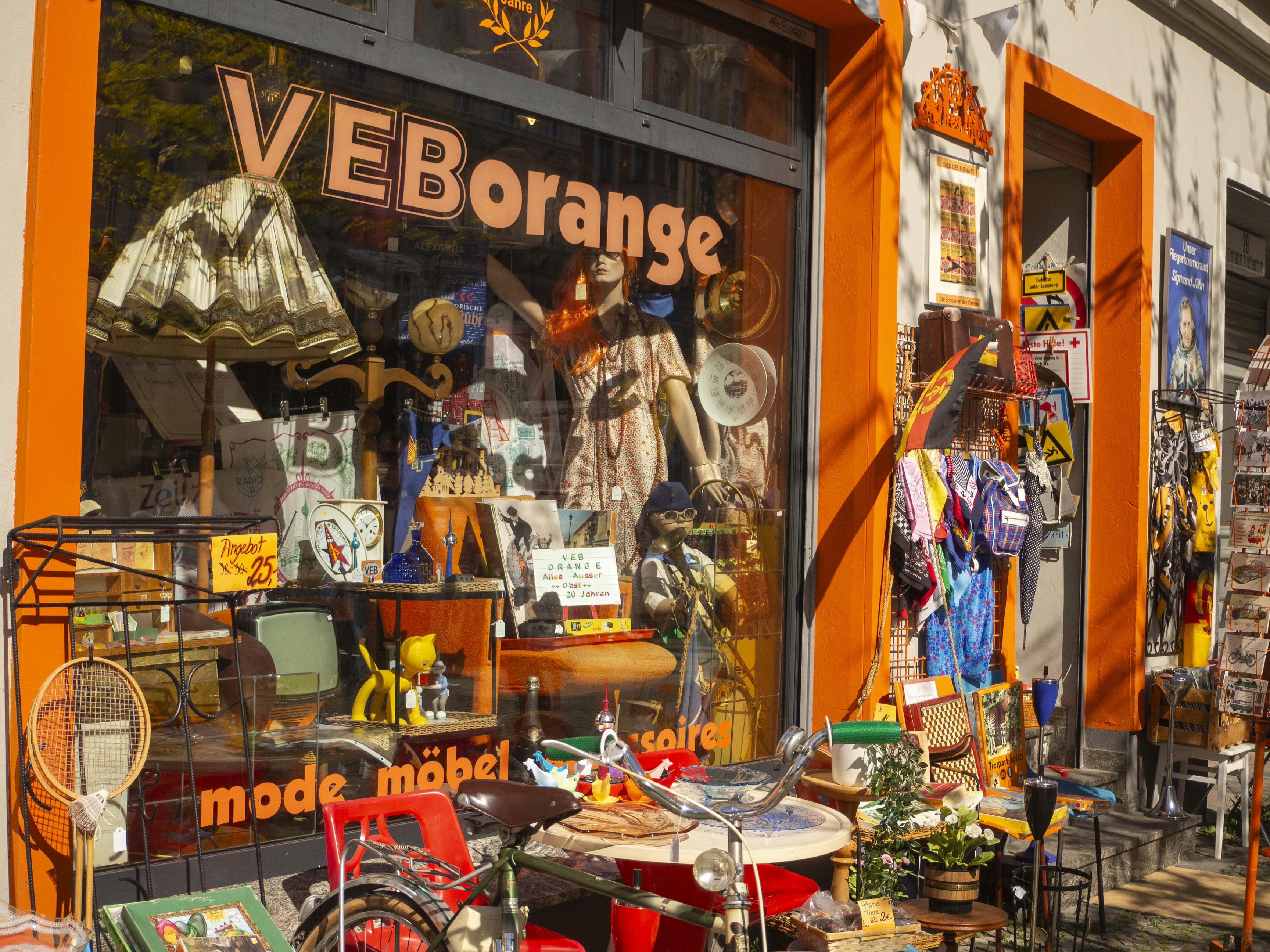 A shop window displays vintage items and clothing.
