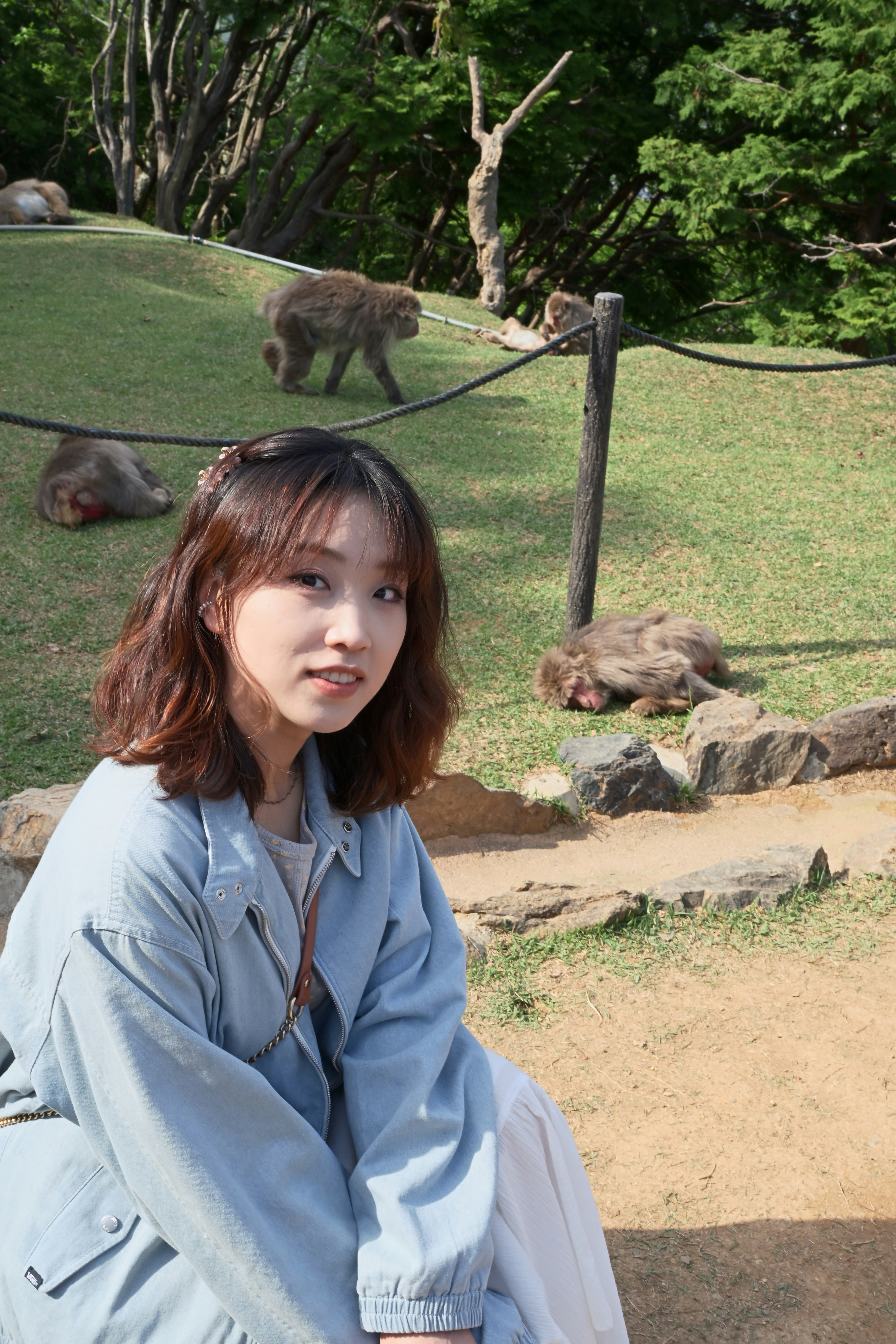 Woman smiles with monkeys in the background.