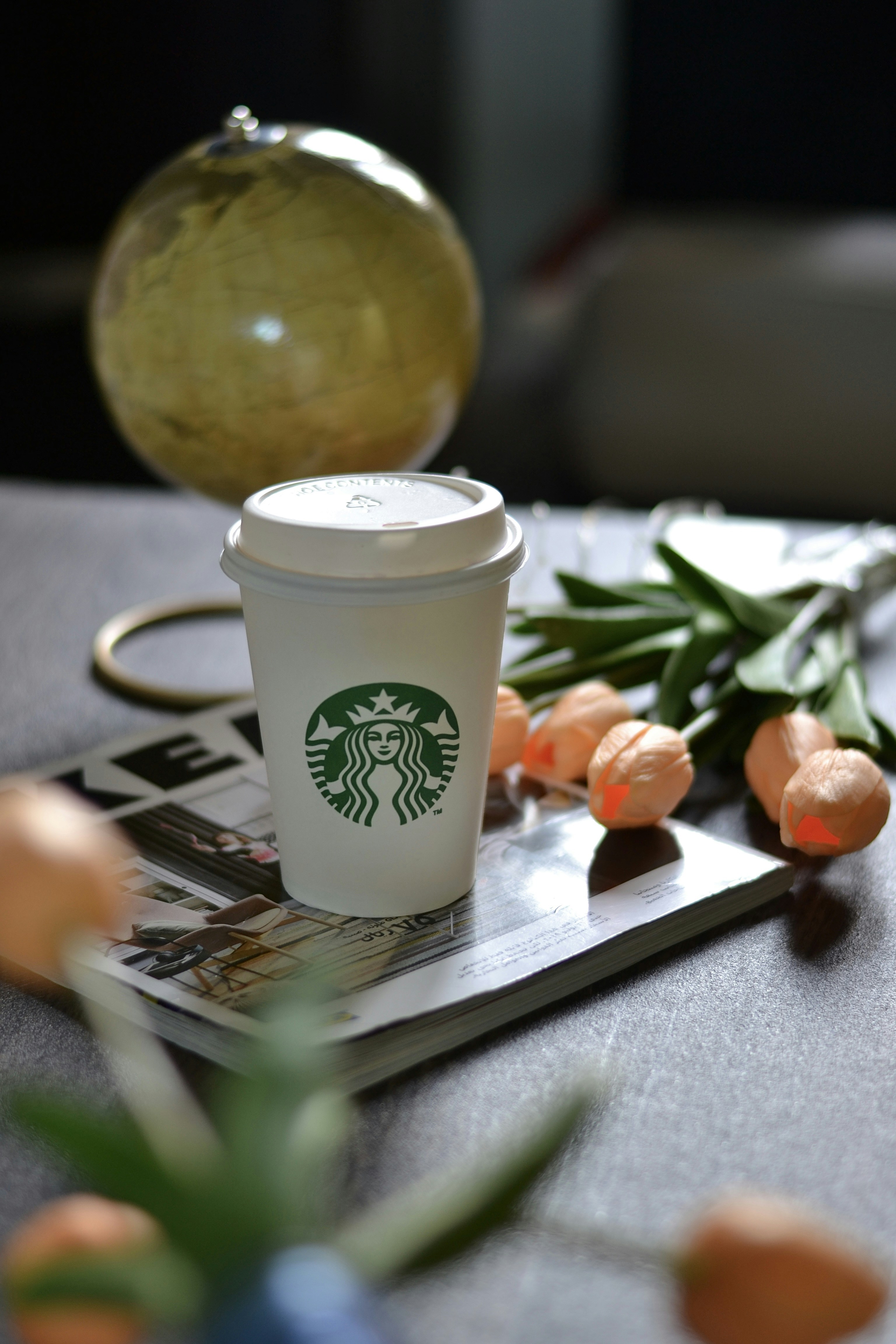 テーブルの上にはスターバックスのコーヒーとフラワーアレンジメント。
