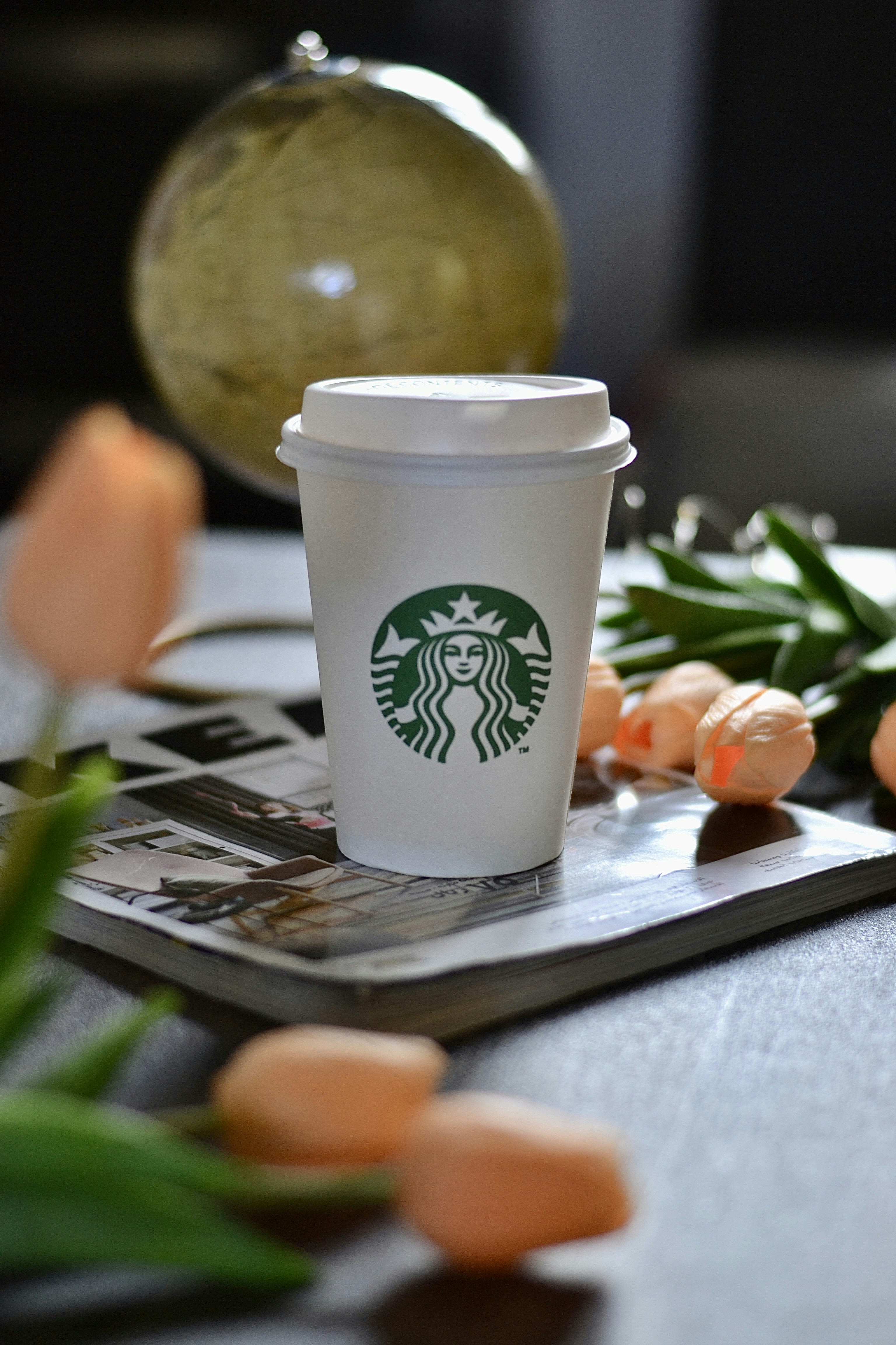 スターバックスのコーヒーカップは雑誌の上に置かれています。