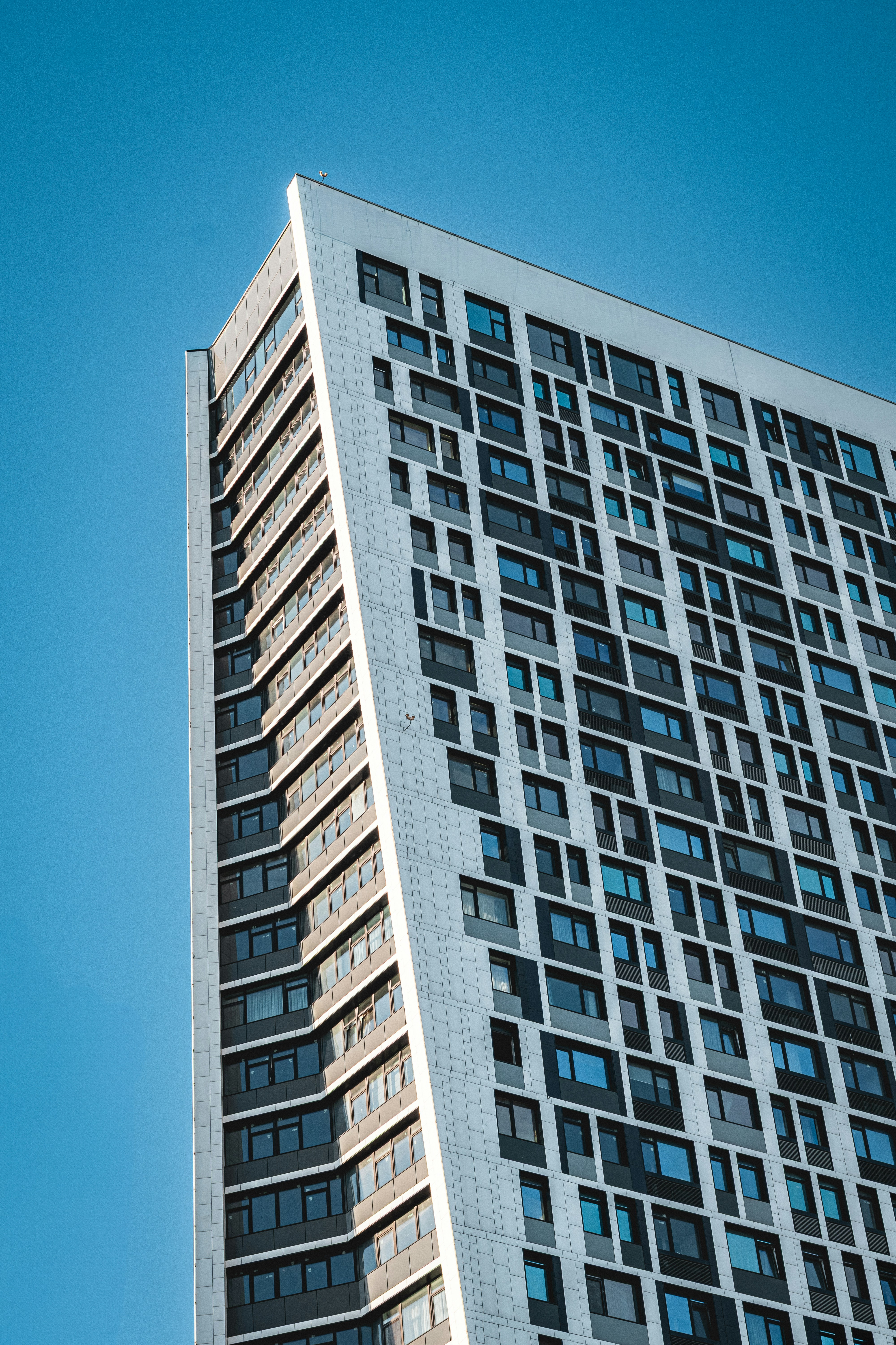 A modern, geometric skyscraper reaches toward the sky.