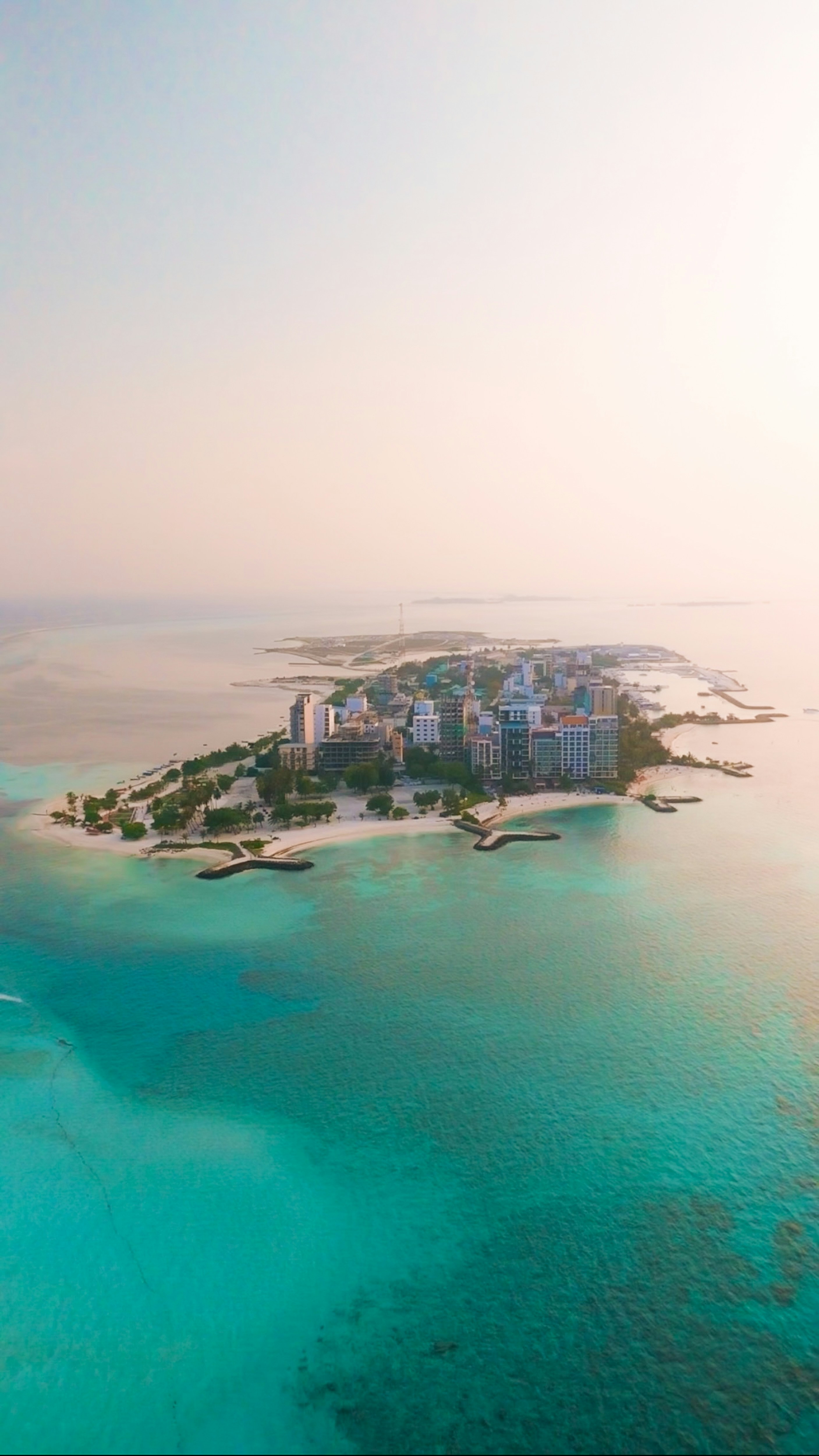 An aerial view of an island city and turquoise water.