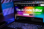 Laptop displays "the ai code editor" website.