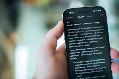 A person reads restaurant recommendations on their phone.