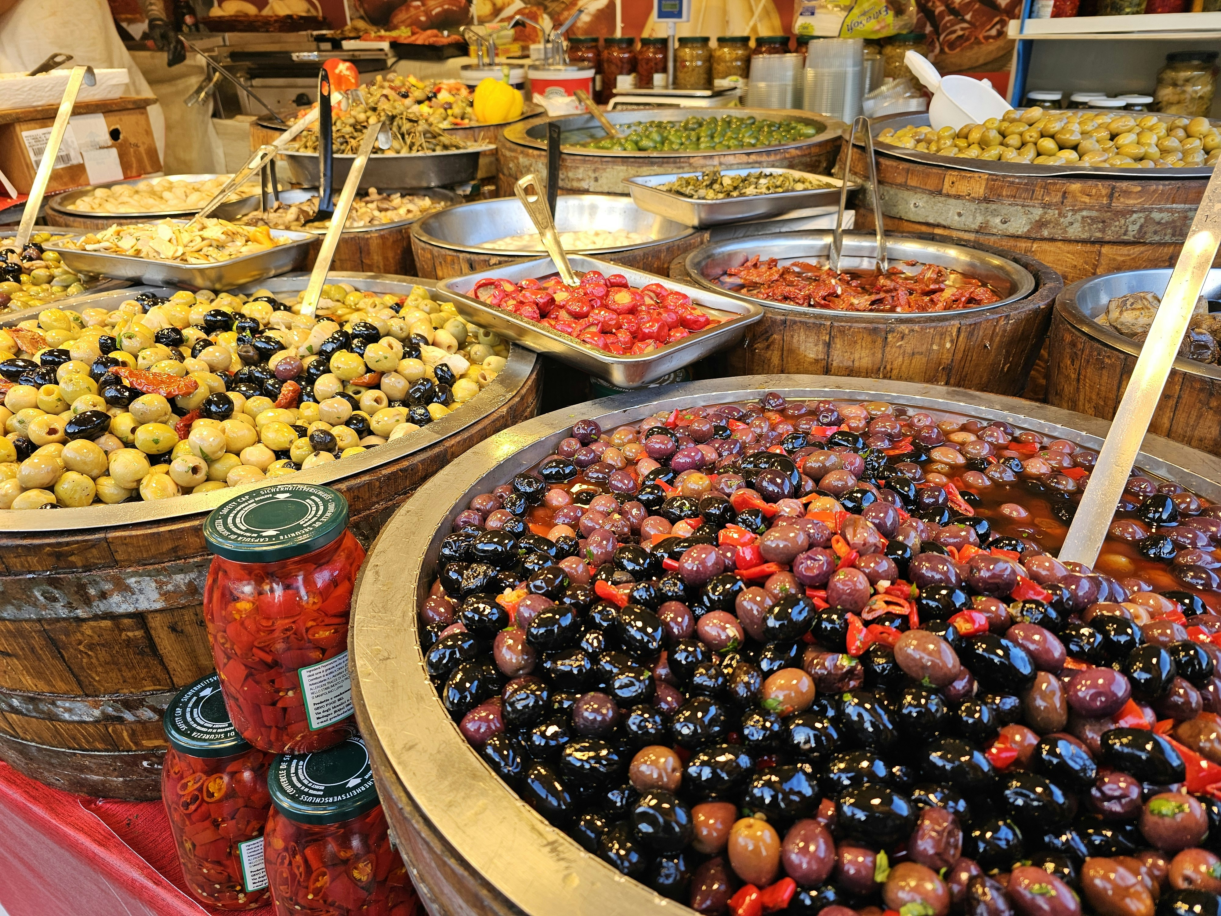 A market stall displays various olives and other foods., Olives in Naples, Italy at an outdoor market
