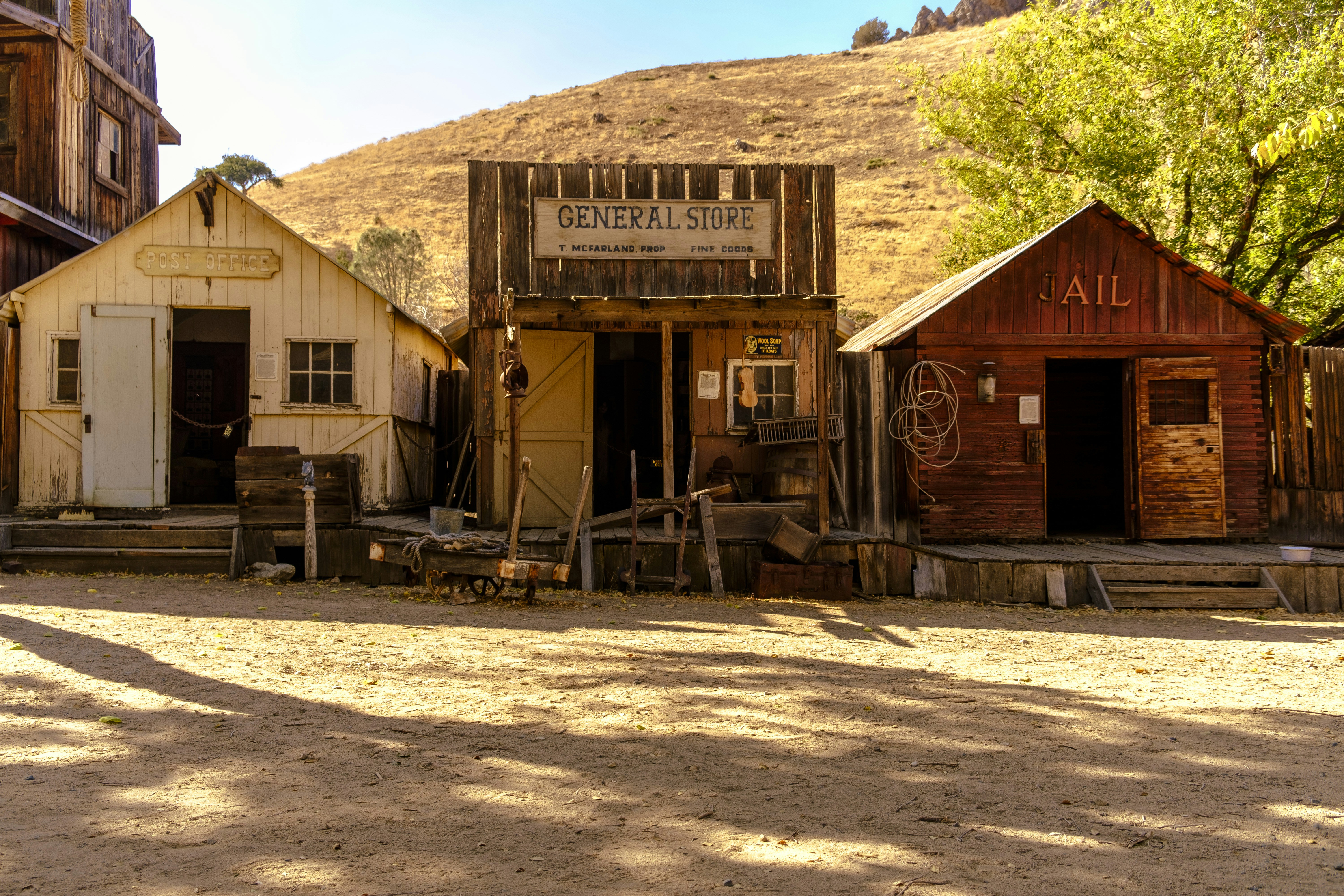 Old western town with three wooden buildings.