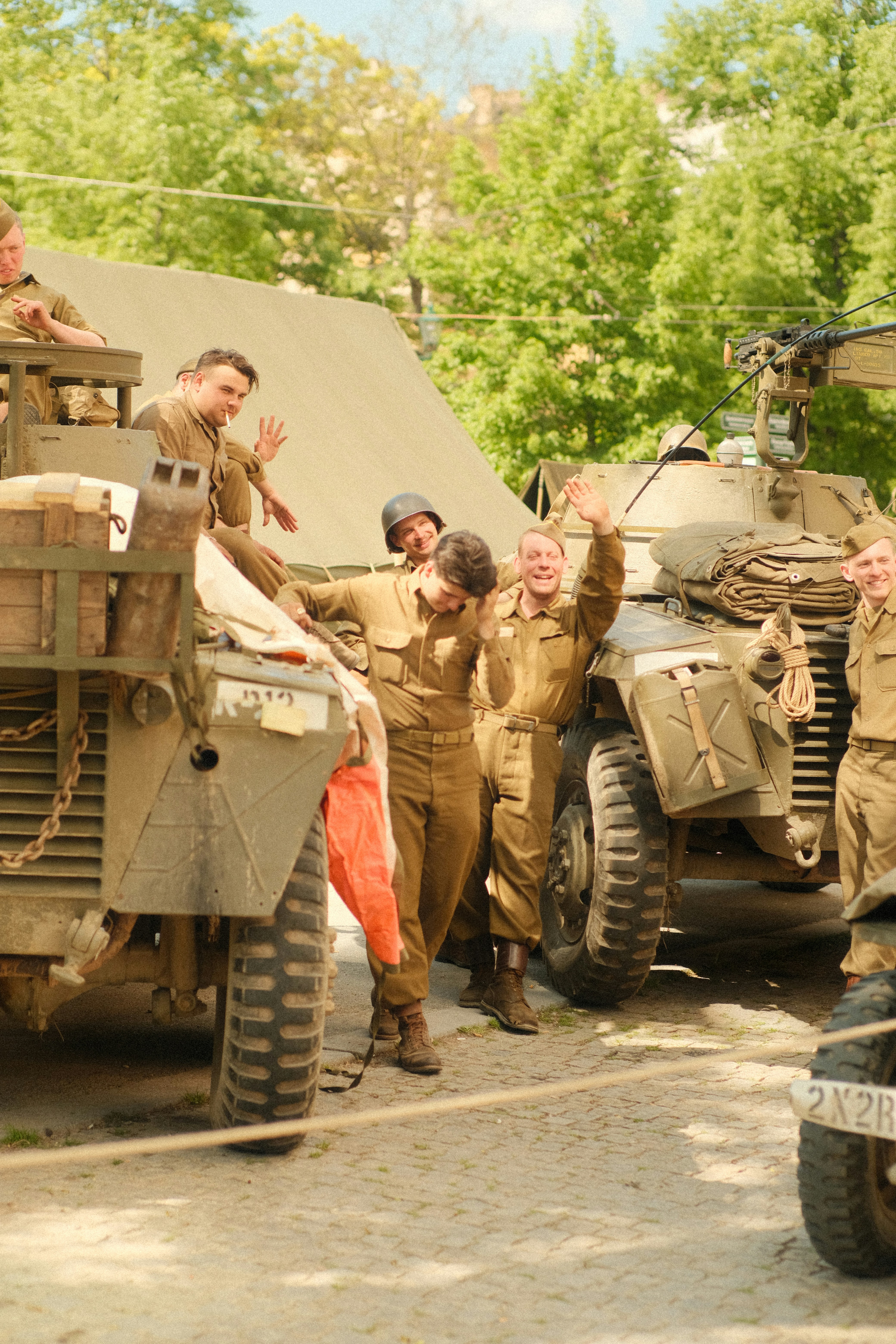 Soldiers in historical attire pose by their vehicles.