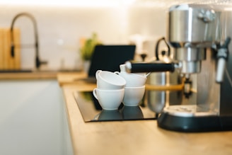 Coffee machine and cups on a modern kitchen counter.
