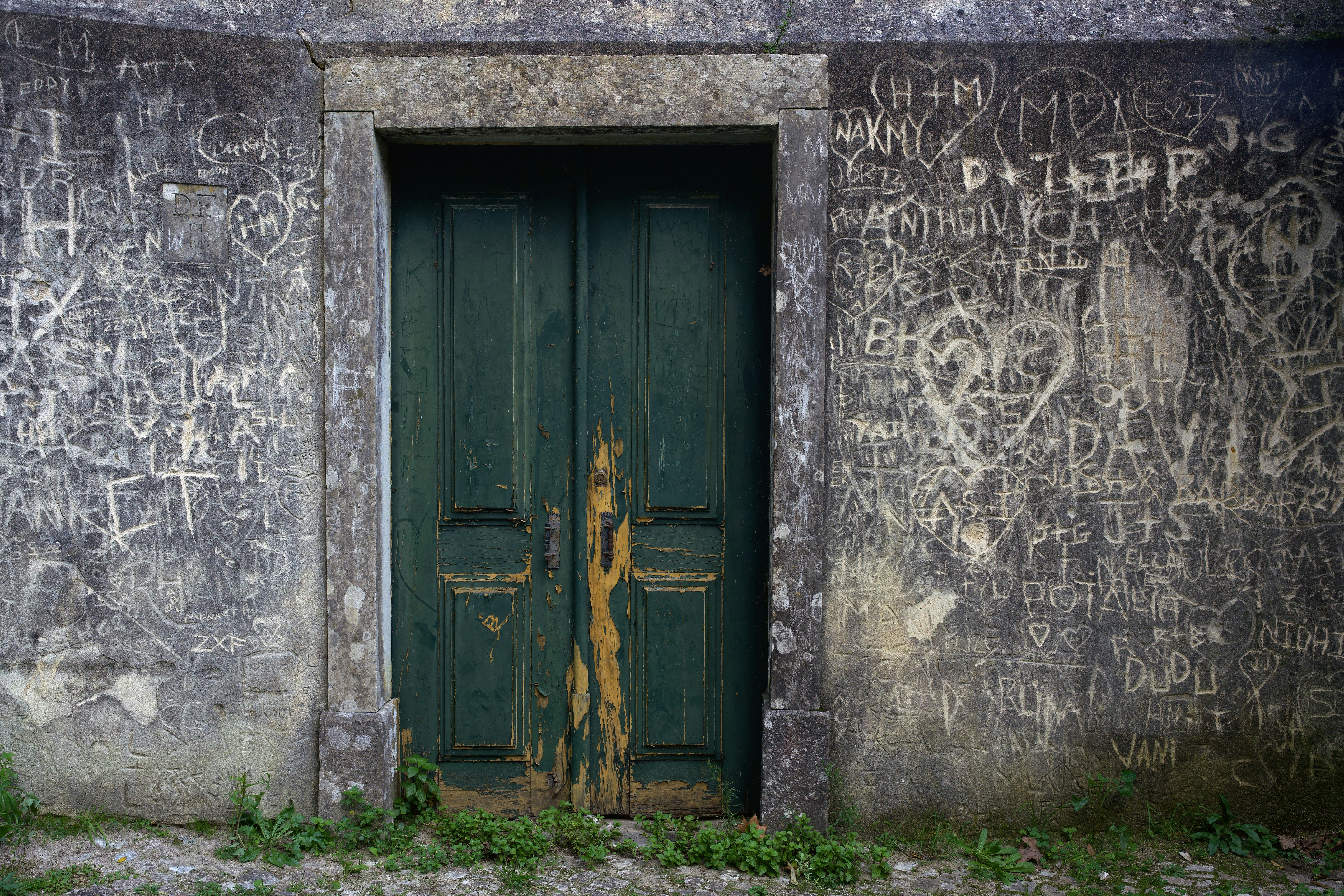 Graffiti covers the walls around a green door