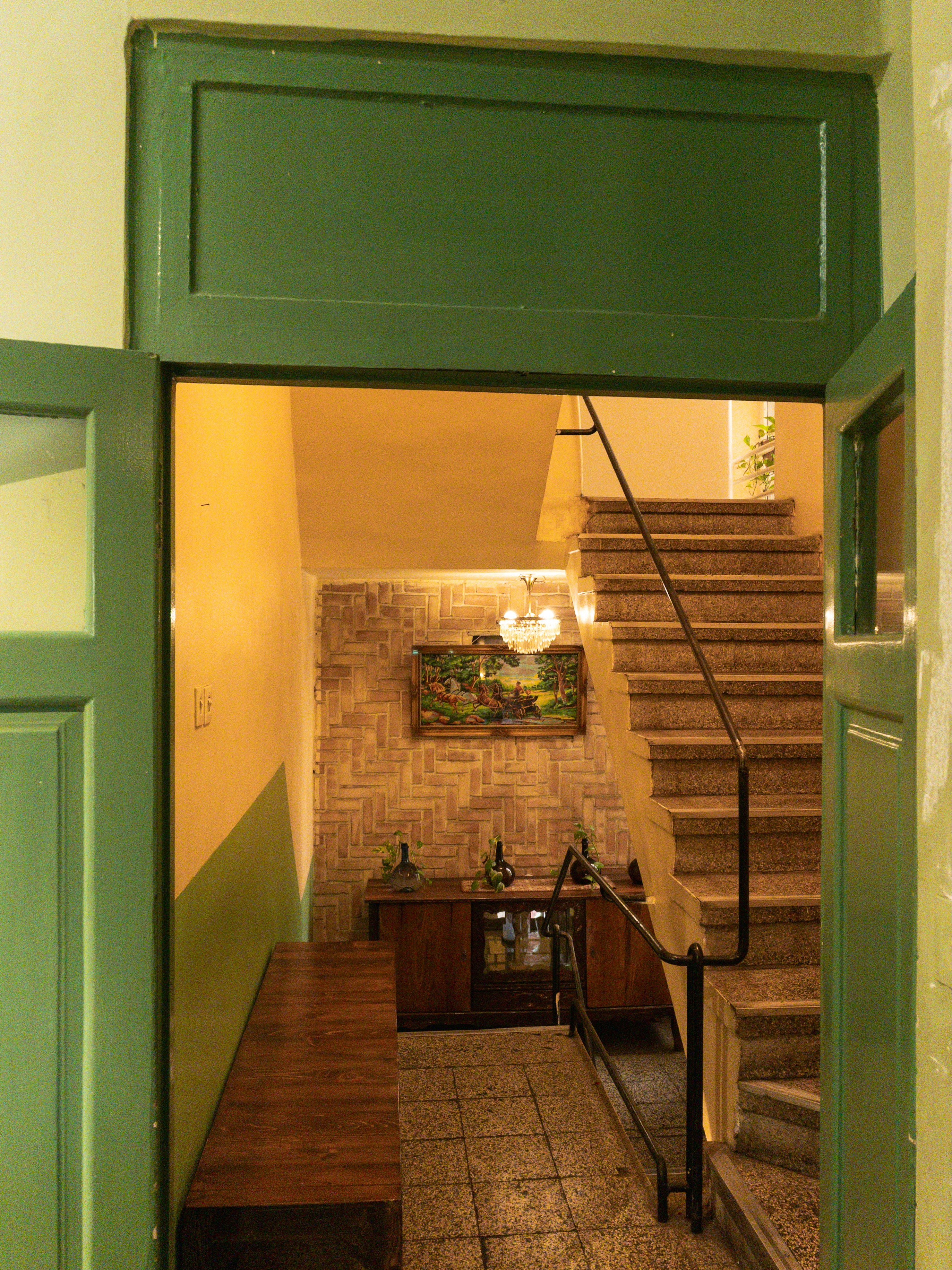 A hallway opens to a staircase and furniture.