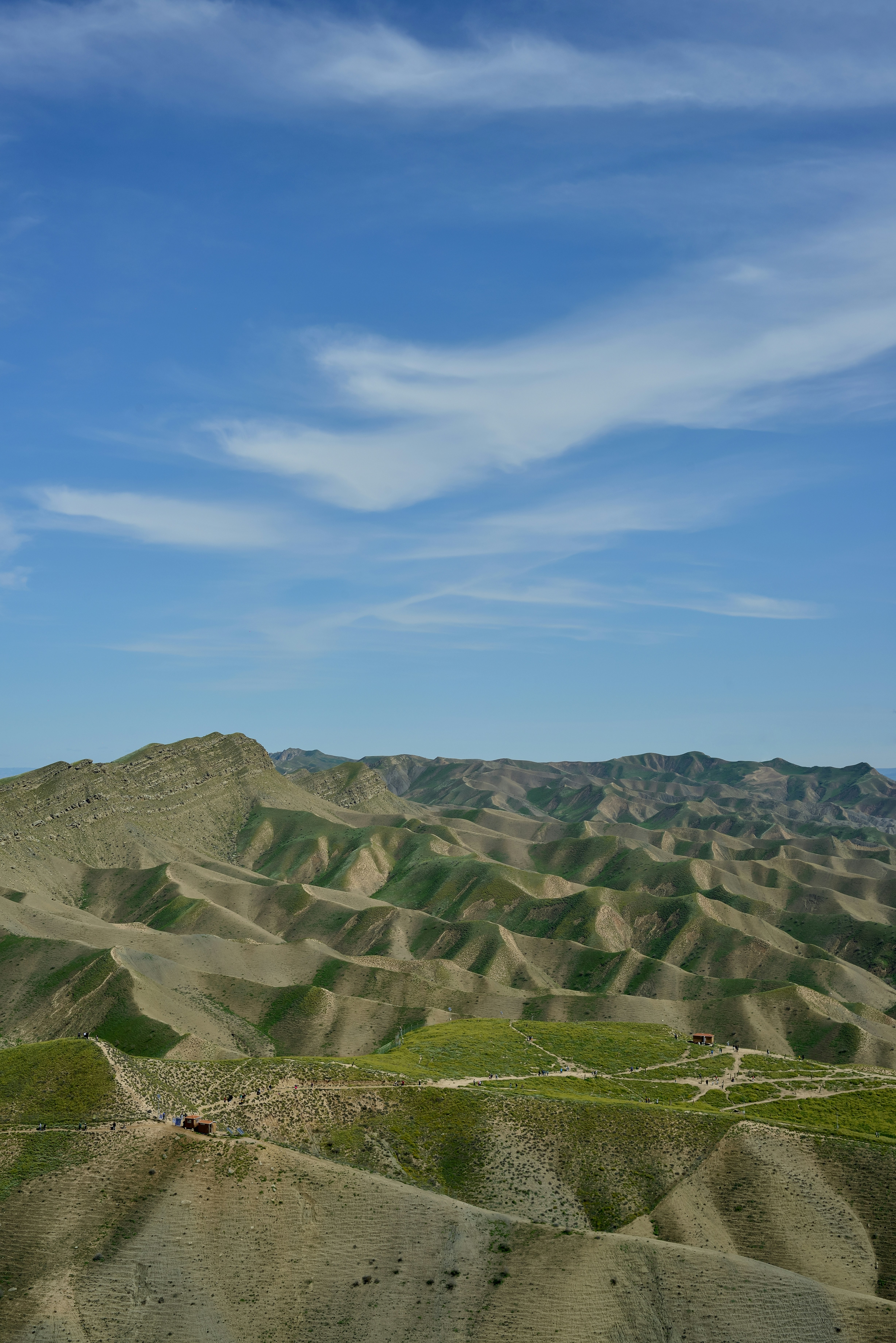 Rolling green hills meet a bright, blue sky.