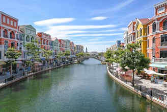 Colorful buildings line a canal with a bridge.