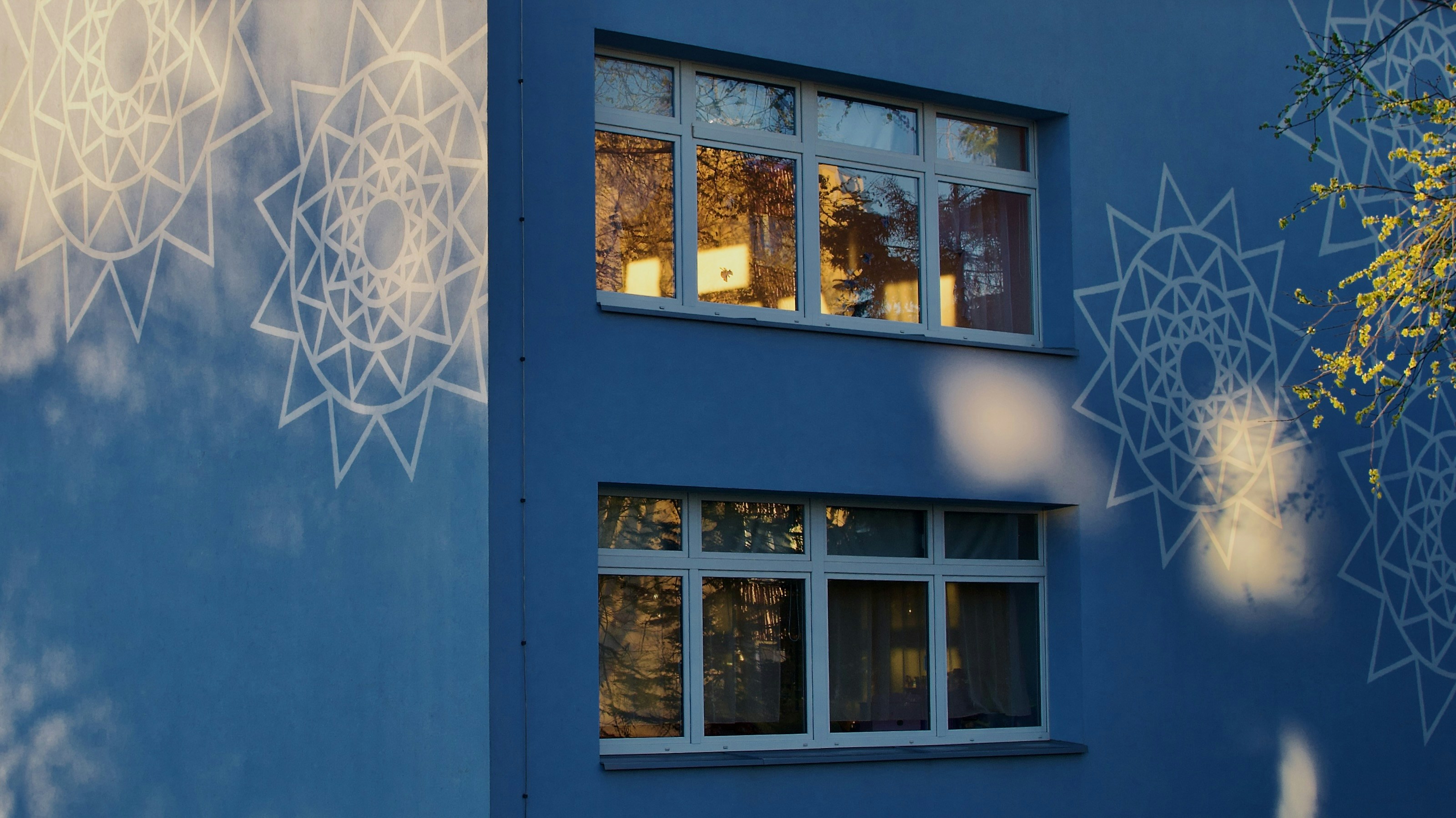 Un edificio azul refleja la luz y las ventanas.