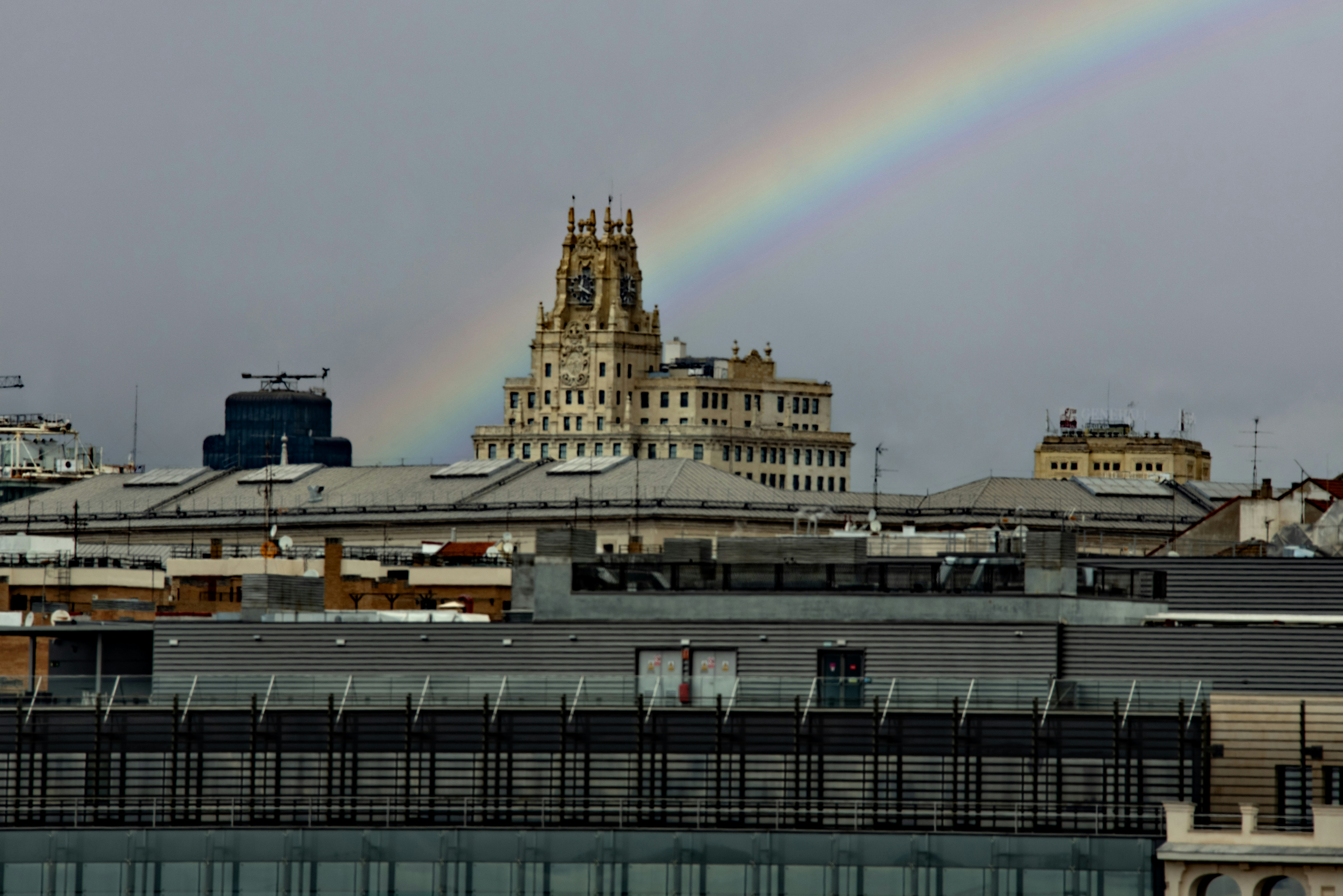A rainbow arches over a city skyline.