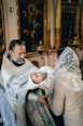 Priest baptizes a baby in a church