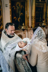 Priest baptizes a baby in a church