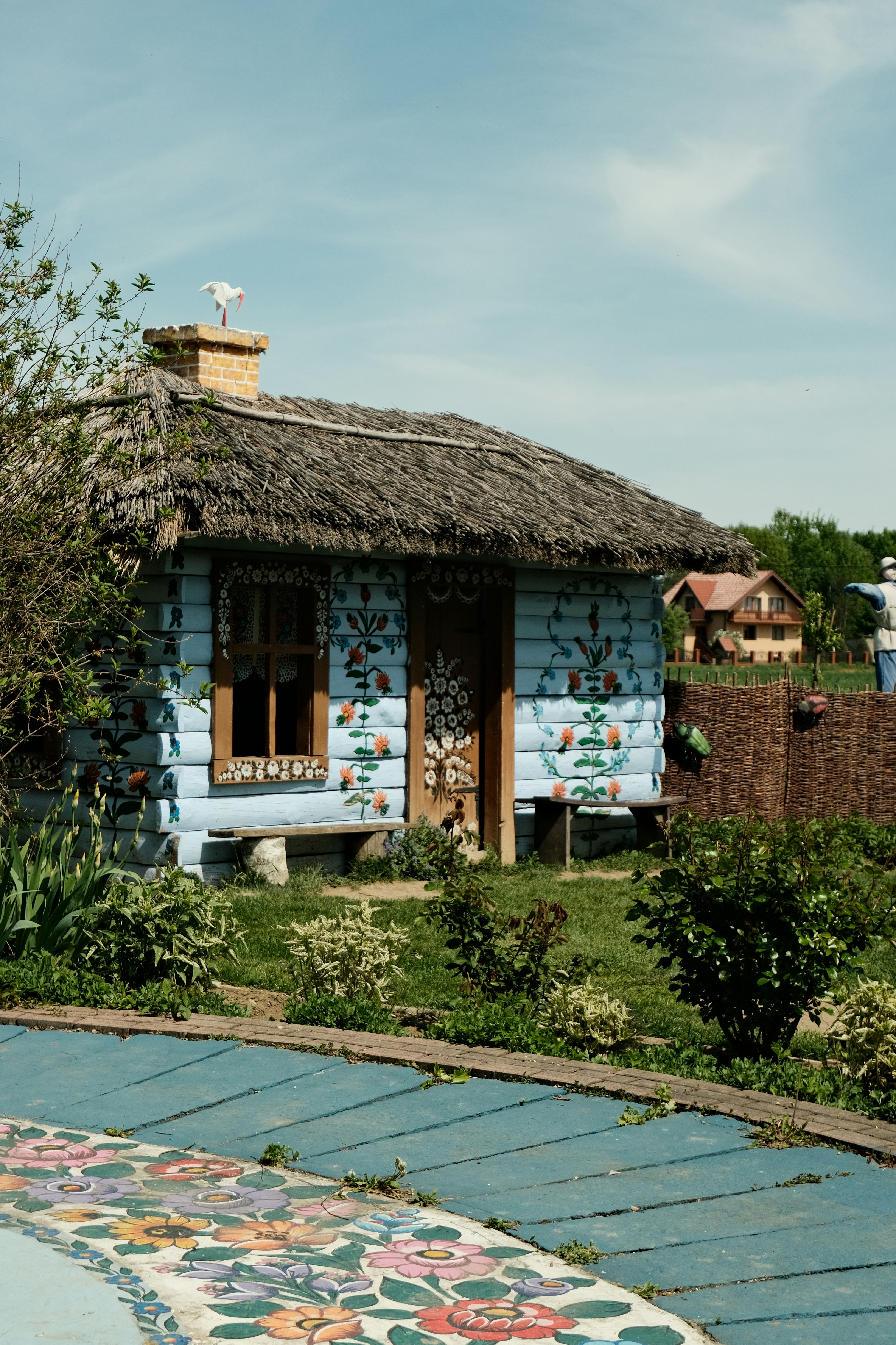 A quaint, blue cottage with floral decorations.