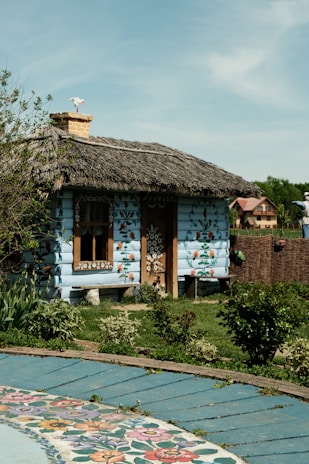 A quaint, blue cottage with floral decorations.