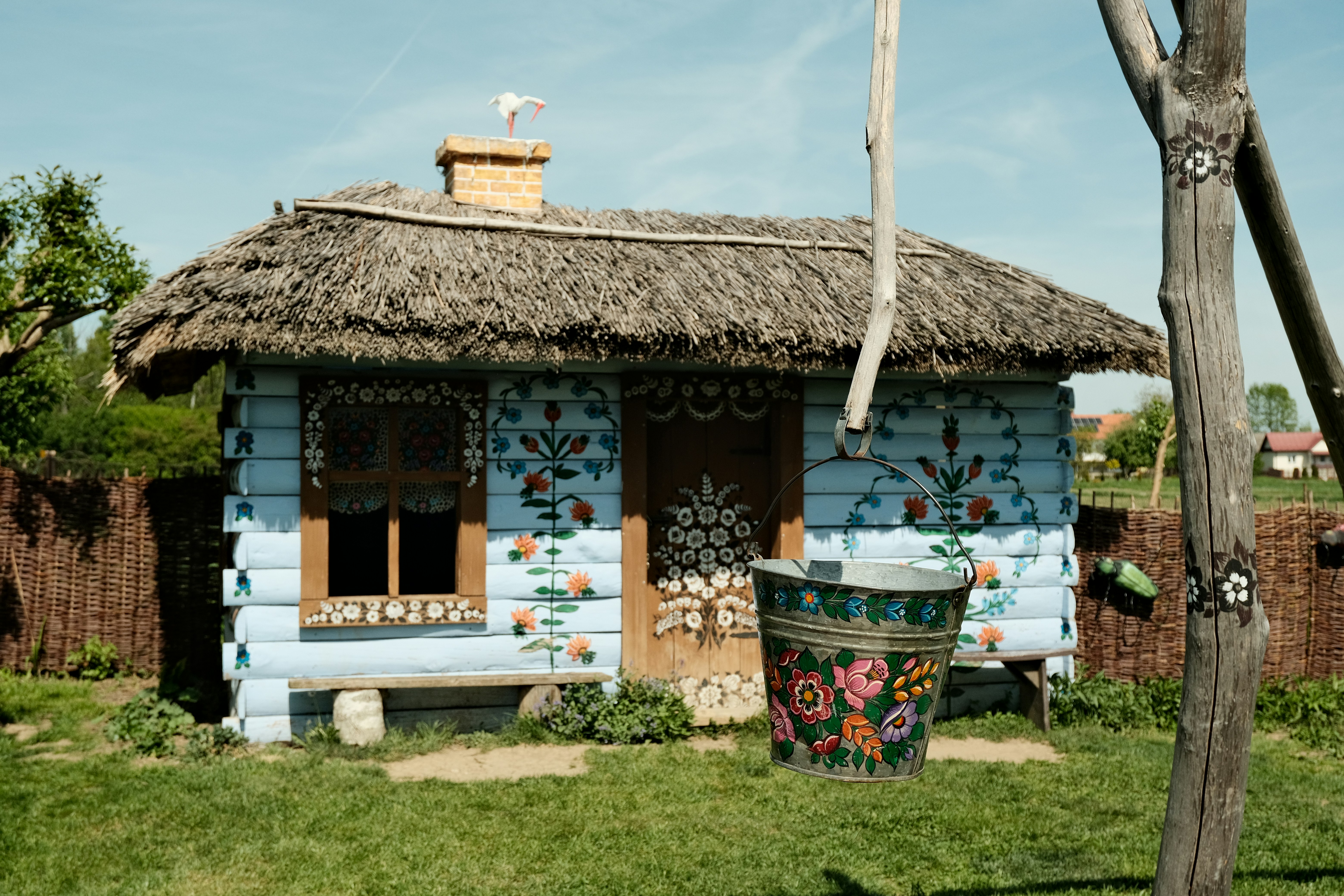 A small blue cottage with a thatched roof.