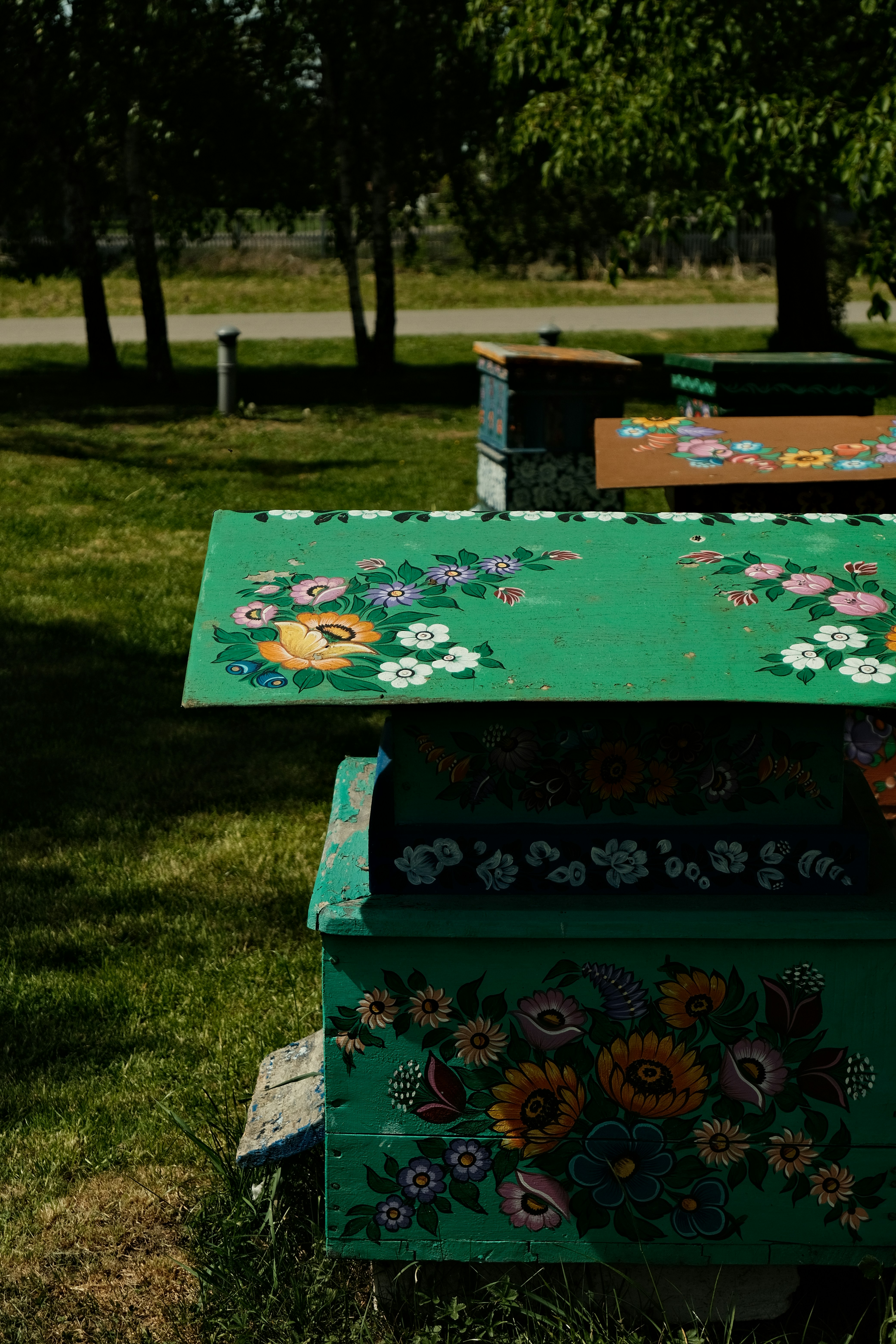 Beehives decorated with colorful floral patterns.
