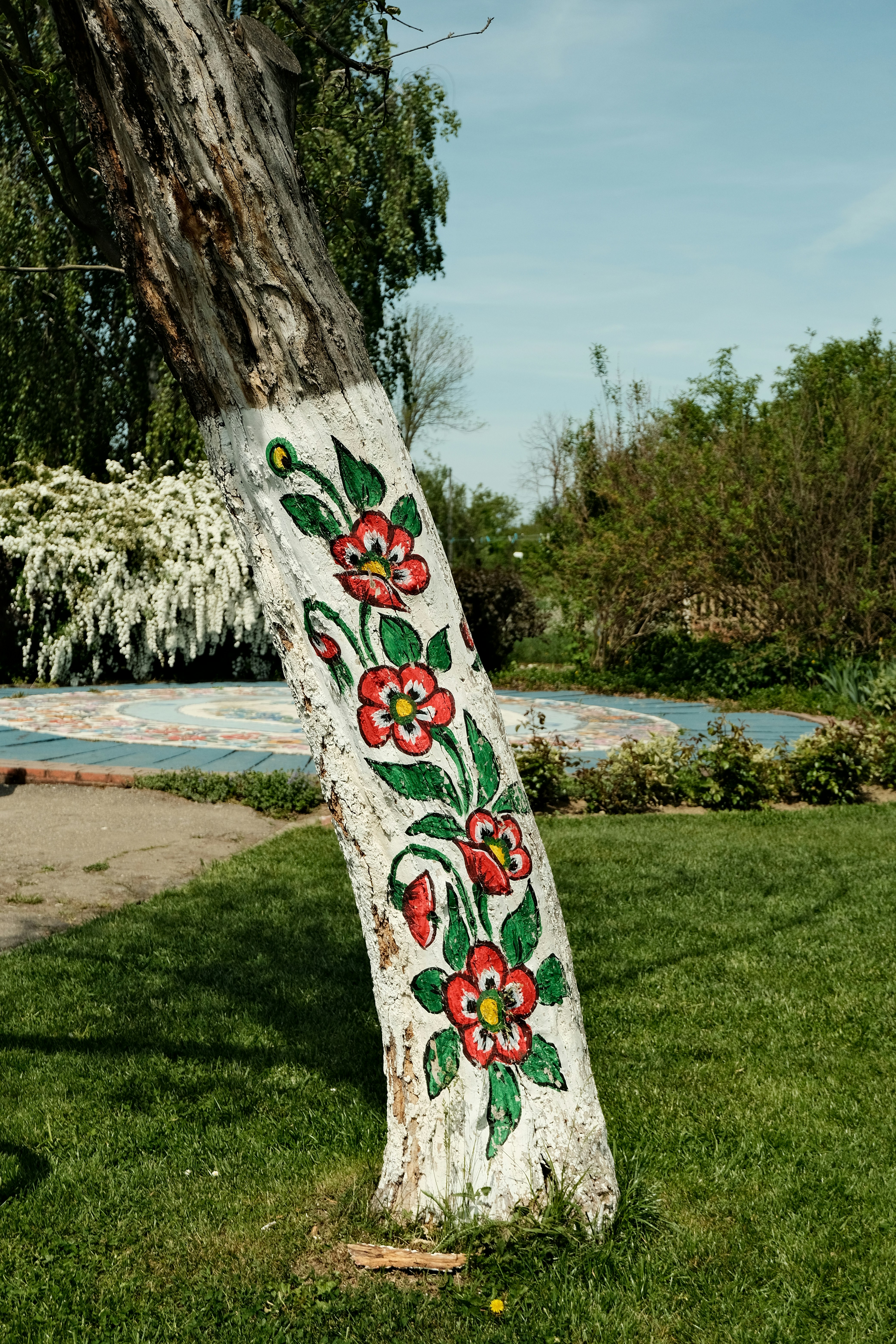 Painted flowers decorate a tree's trunk.
