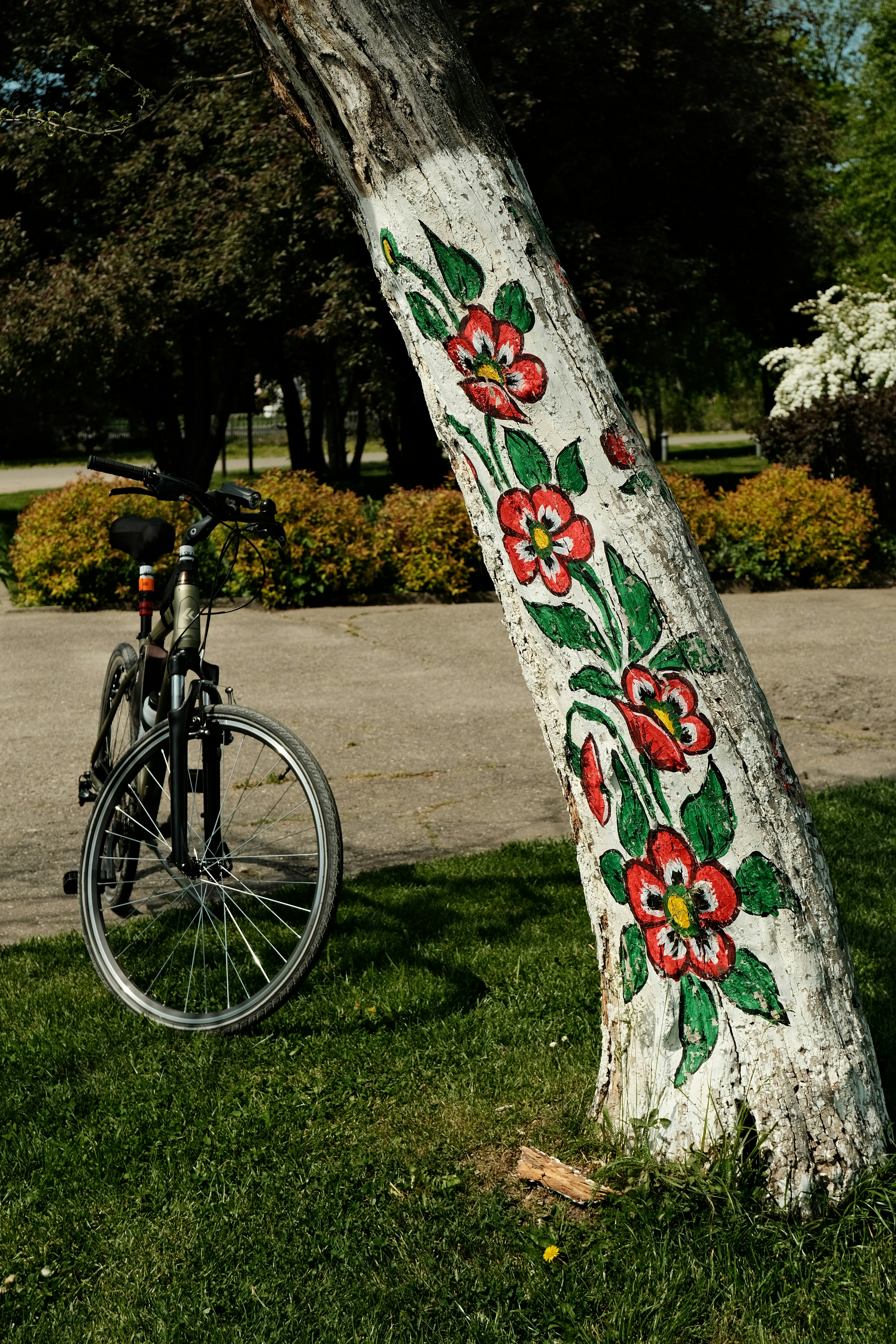 A tree with painted flowers and a bicycle.